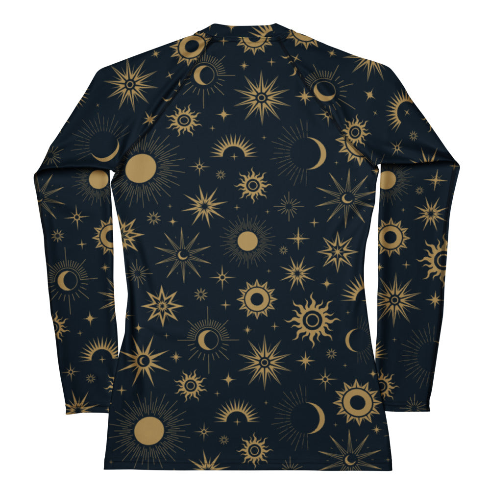 A navy blue womens long sleeve rash guard with a vibrant gold celestial pattern and buttery soft fabric with UPF 50+