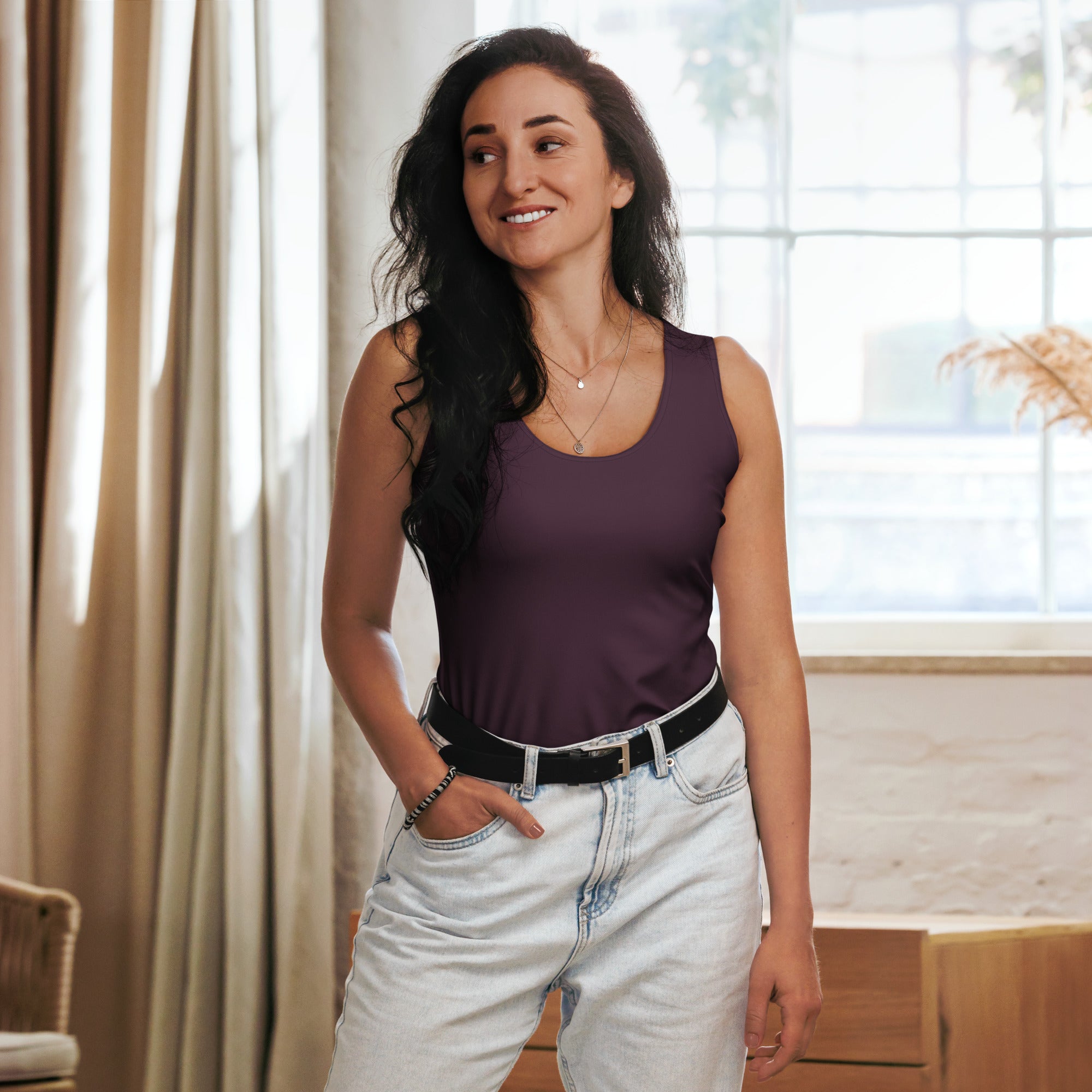 A woman wears a fitted sleeveless plum purple tank top made of quick drying buttery soft fabric with UPF 50+ protection