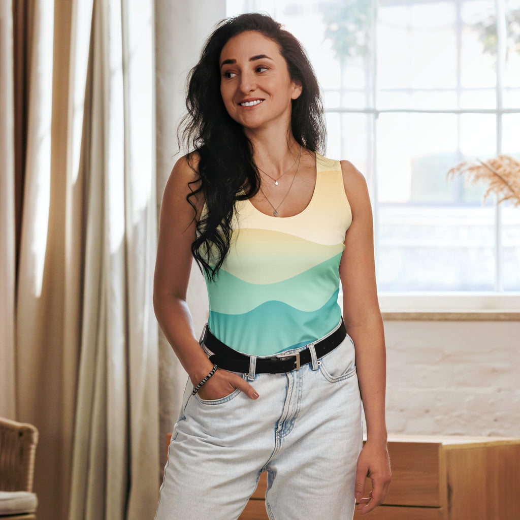 A woman wearing a women’s coastal wave tank top with buttery soft fabric in yellow to teal gradient stripes