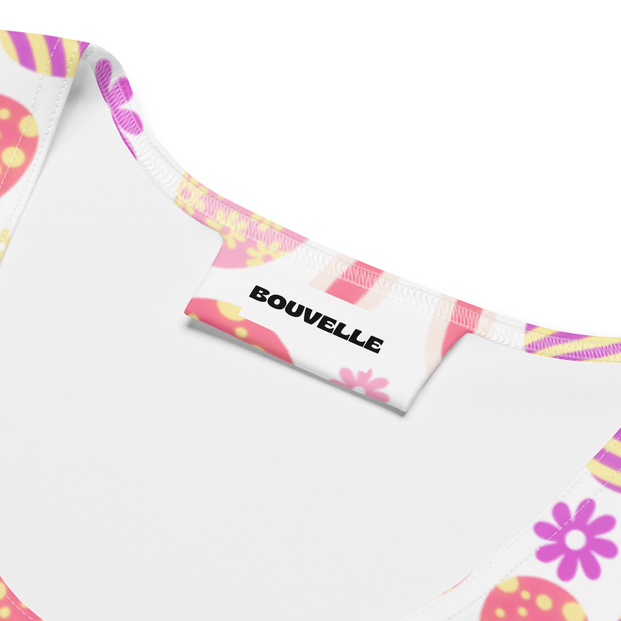 A white fabric tag with bouvelle on a womens cute bunny easter tank top with pink flowers yellow eggs and upf 50+
