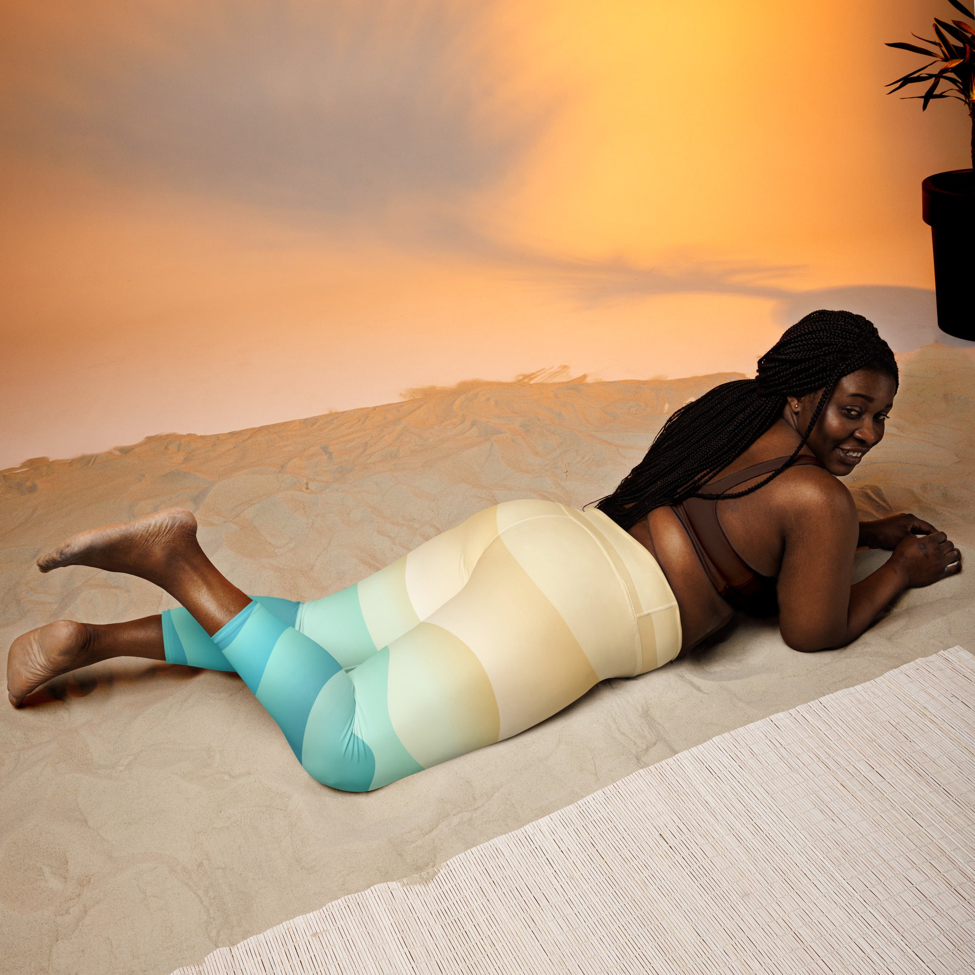 A woman wearing women’s coastal gradient buttery soft yoga capri leggings in teal to cream high-rise stretch fabric