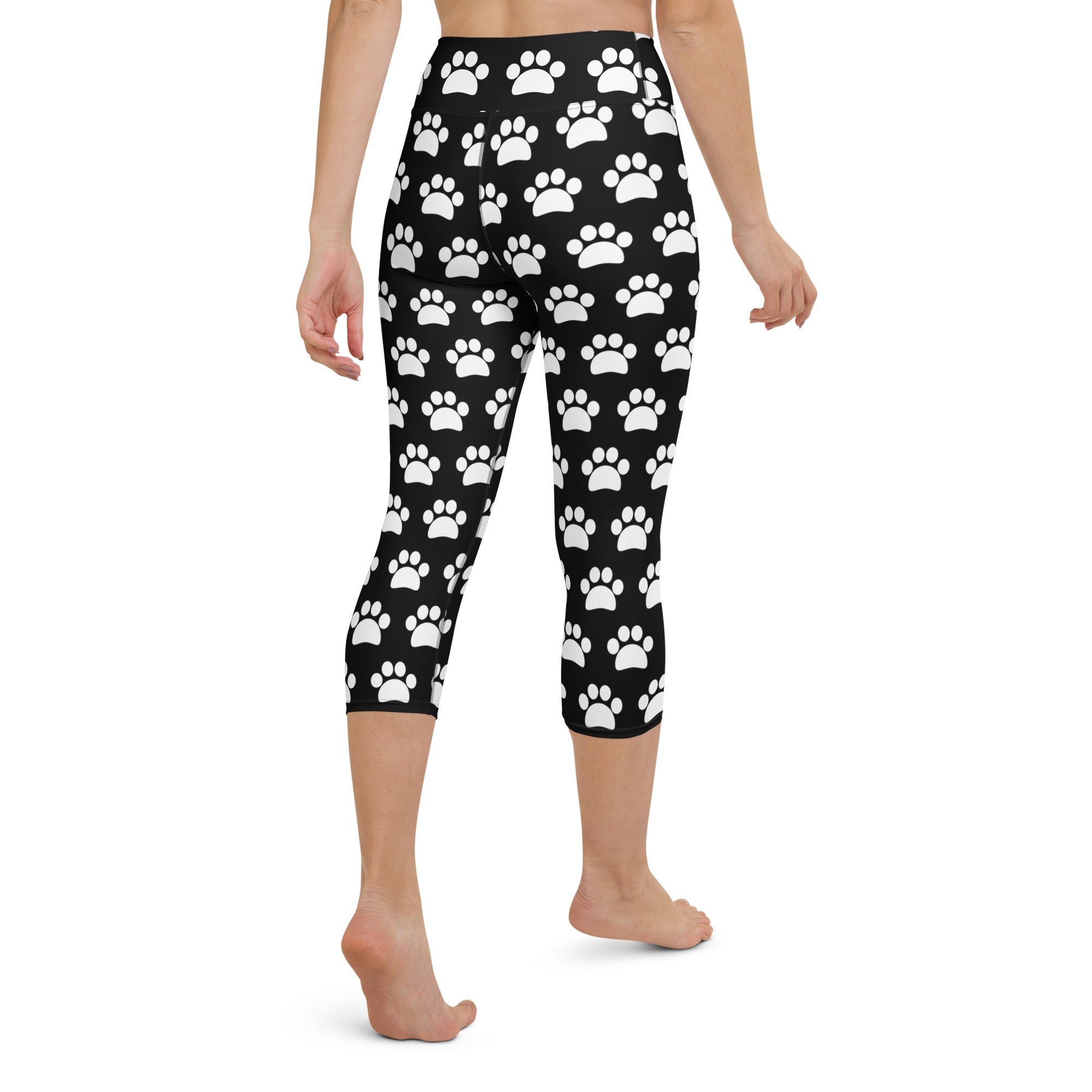 Women’s black buttery soft high-rise yoga capri leggings with white paw print pattern and moisture-wicking fabric