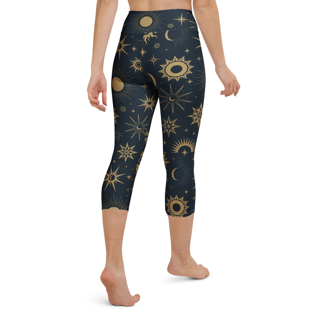 Dark blue high-rise buttery soft yoga capri leggings with gold sun moon and star celestial pattern and moisture-wicking fabric