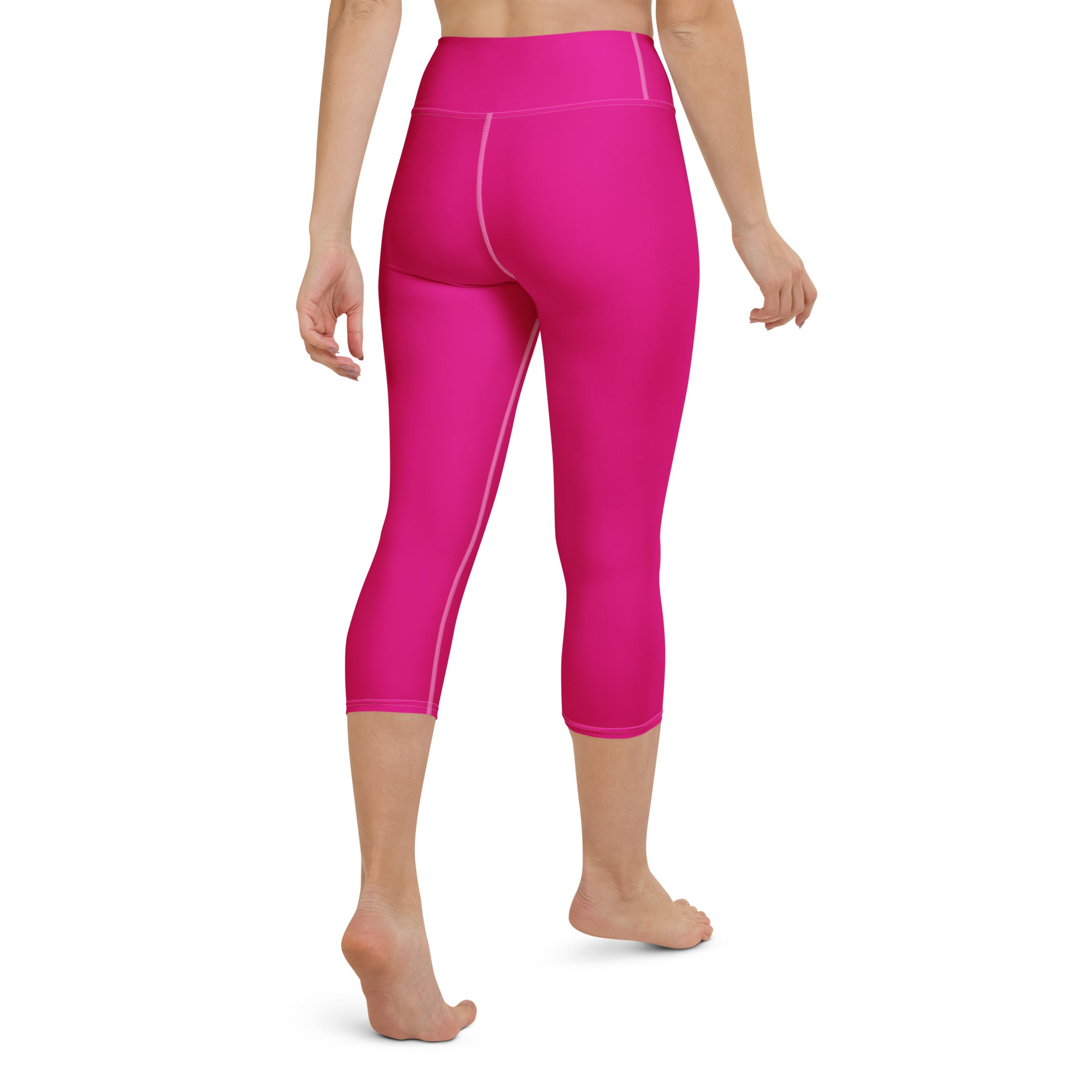 Women’s hot pink buttery soft high-rise yoga capri leggings with subtle white seam detailing and moisture-wicking fabric
