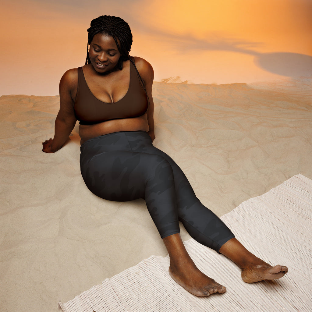 A woman wearing black camouflage buttery soft high-rise moisture-wicking yoga capri leggings from the back