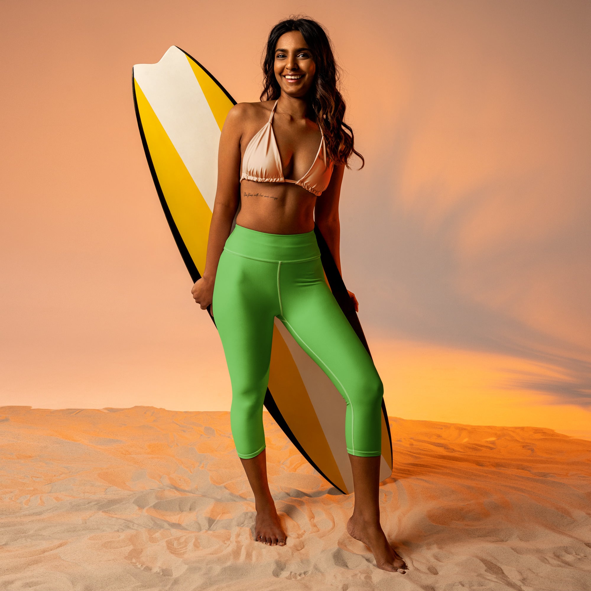 A vibrant green women’s buttery soft capri-length high-rise yoga leggings with moisture-wicking stretch fabric paired with a matching bikini top