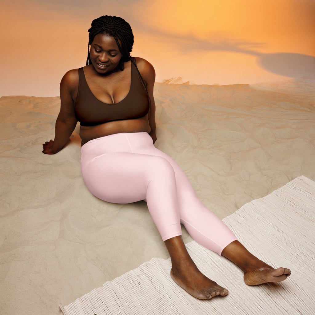 A pair of women’s light pink buttery soft high-rise yoga capri leggings made of smooth stretchy moisture-wicking fabric