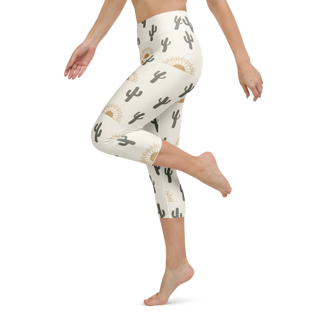 Cream-colored women’s desert sunrise cactus buttery soft high-rise capri leggings with black cacti and gold sunbursts
