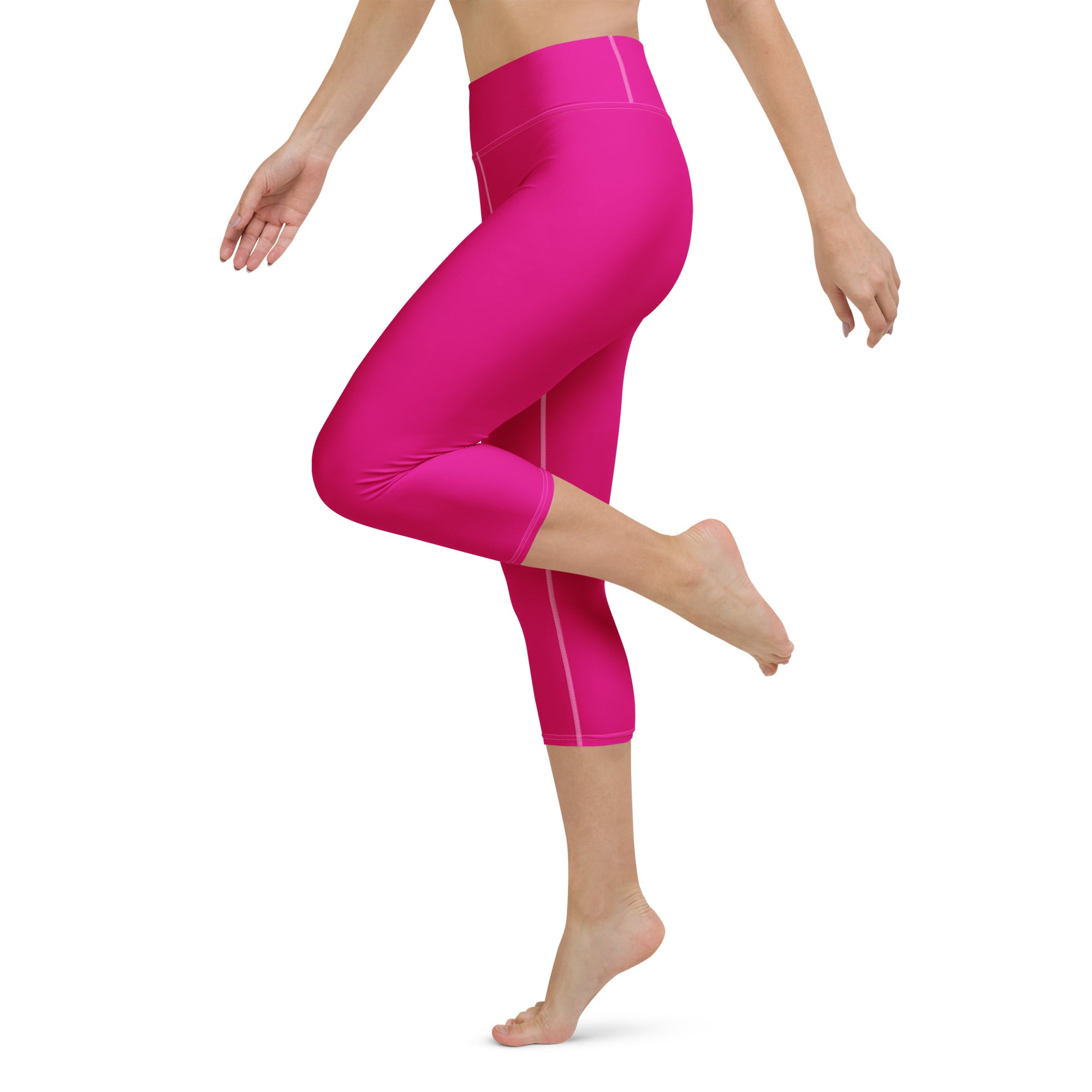 Women’s hot pink buttery soft high-rise yoga capri leggings with subtle white stitching and moisture-wicking fabric