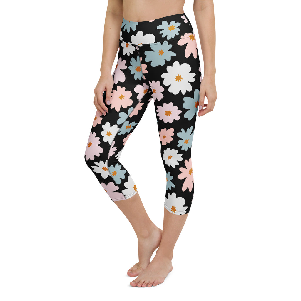 Black high-rise buttery soft yoga capri leggings with pastel pink white and blue daisy floral pattern and moisture-wicking fabric