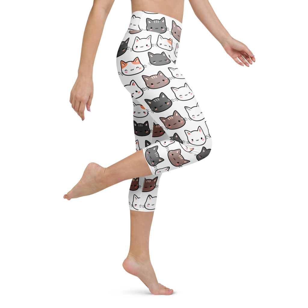 White high-rise capri leggings with colorful cartoon cat faces made from soft, stretchy, moisture-wicking fabric for yoga