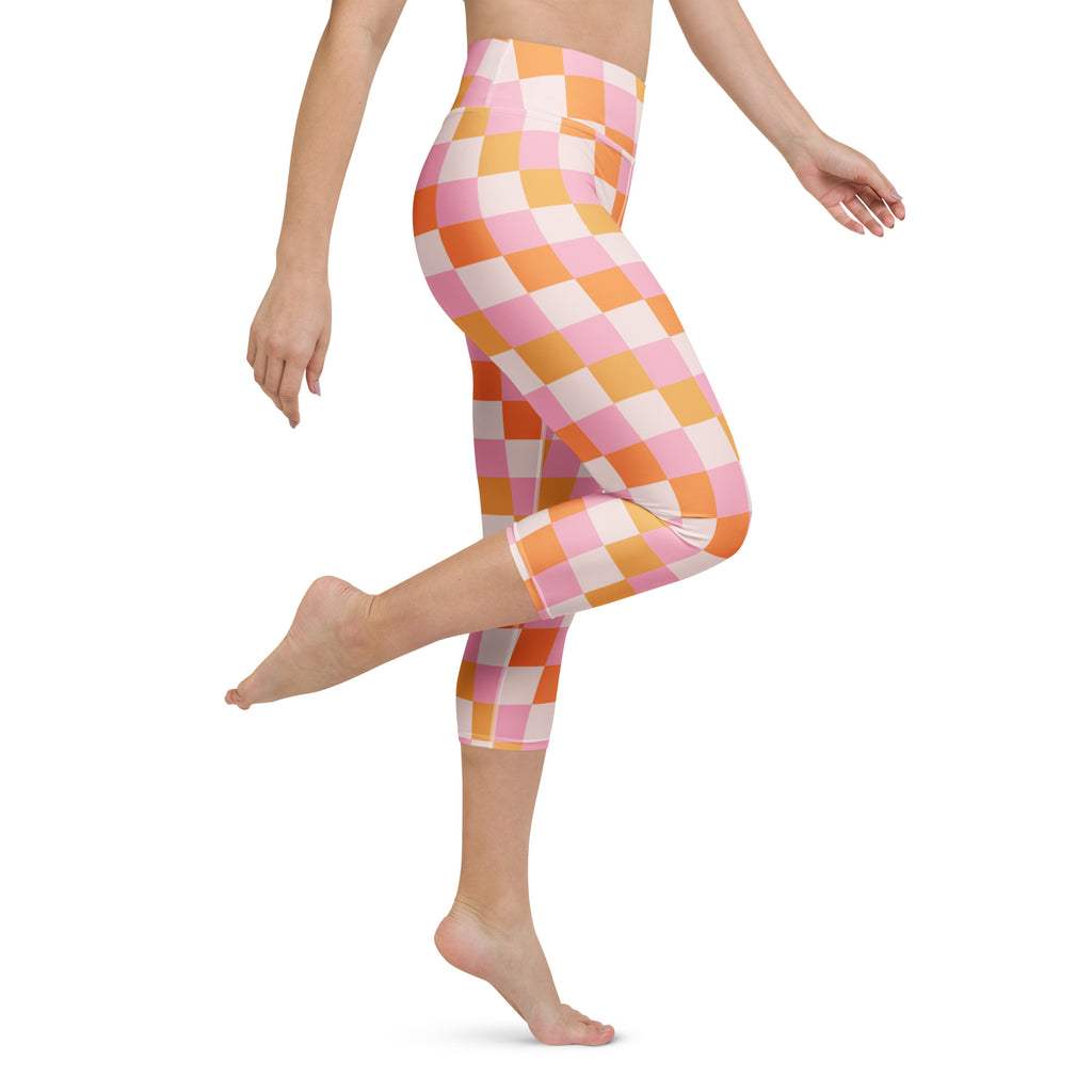 High-waisted capri leggings with vibrant pink and orange checkerboard pattern in buttery soft moisture-wicking fabric