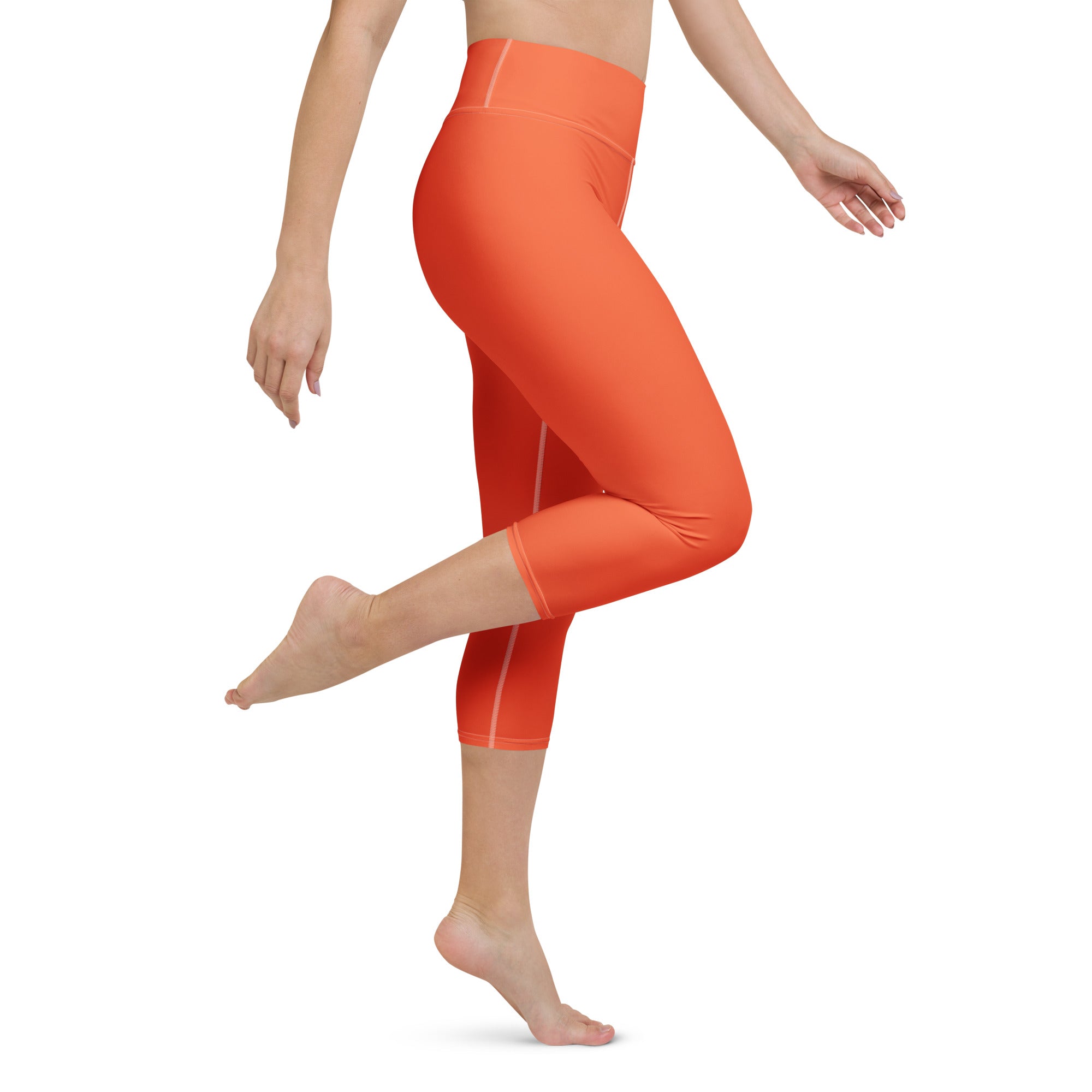 Bright orange buttery soft high-rise yoga capri leggings with smooth stretchy fabric and subtle side seam detailing