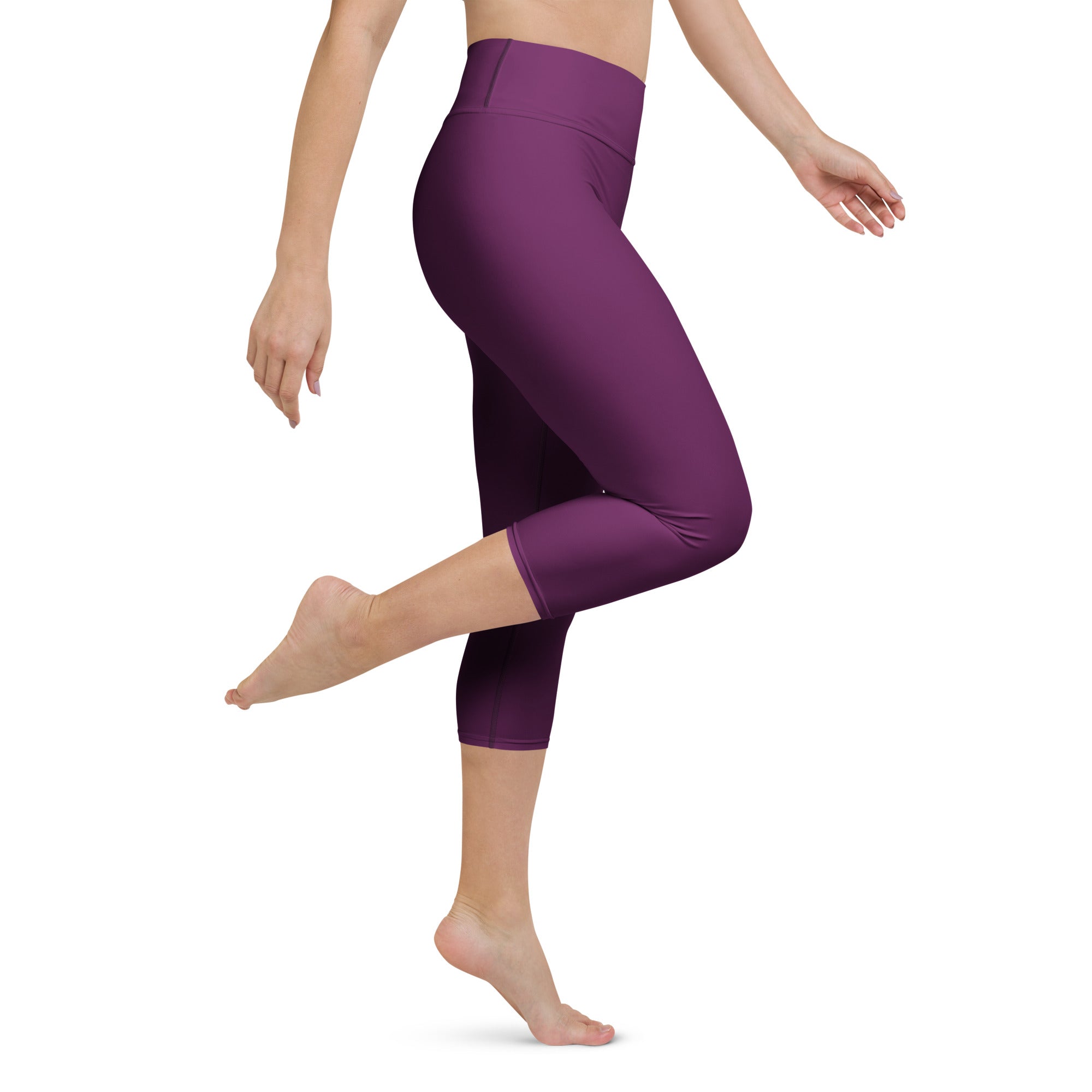 Woman wearing plum purple high-waisted buttery soft yoga capri leggings with moisture-wicking stretch fabric