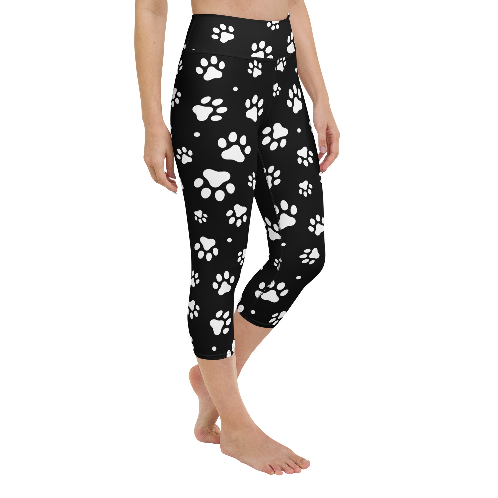 Black high-rise capri leggings with white paw print pattern made from buttery soft moisture-wicking fabric