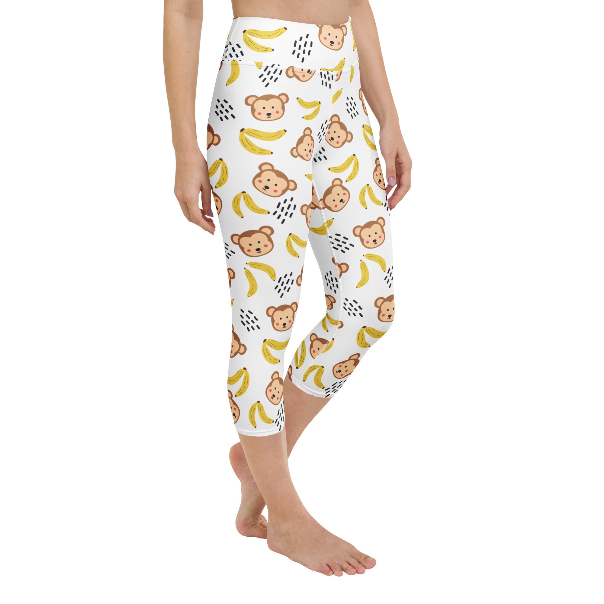 White capri leggings with brown cartoon monkeys and yellow bananas featuring high-rise moisture-wicking stretch