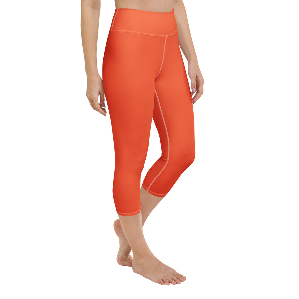Bright orange high-waisted buttery soft yoga capri leggings with subtle seam detailing and moisture-wicking stretch fabric