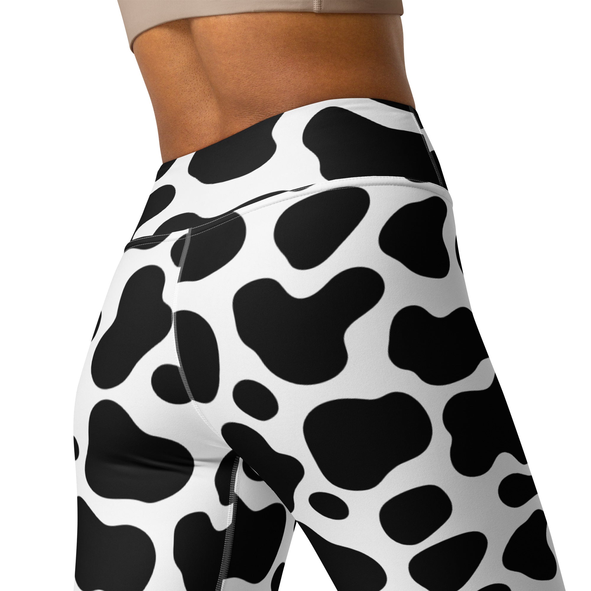 Women’s high-waisted black and white cow print buttery soft yoga leggings shown from the back side