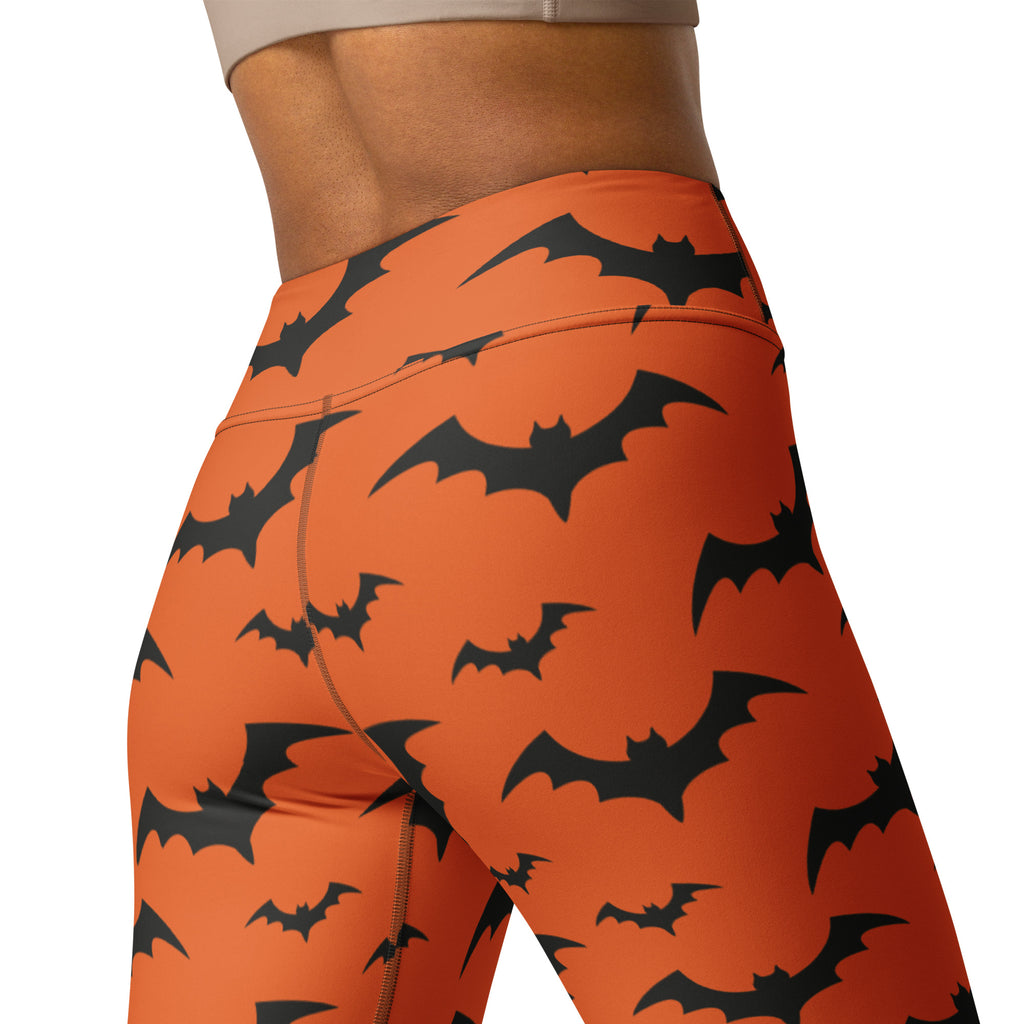 Women’s orange high-waisted yoga leggings with black bat pattern perfect for halloween workouts