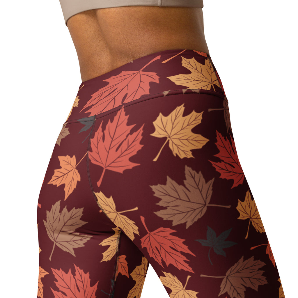 Women’s maroon buttery soft yoga leggings with vibrant autumn maple leaf pattern in orange red and gold