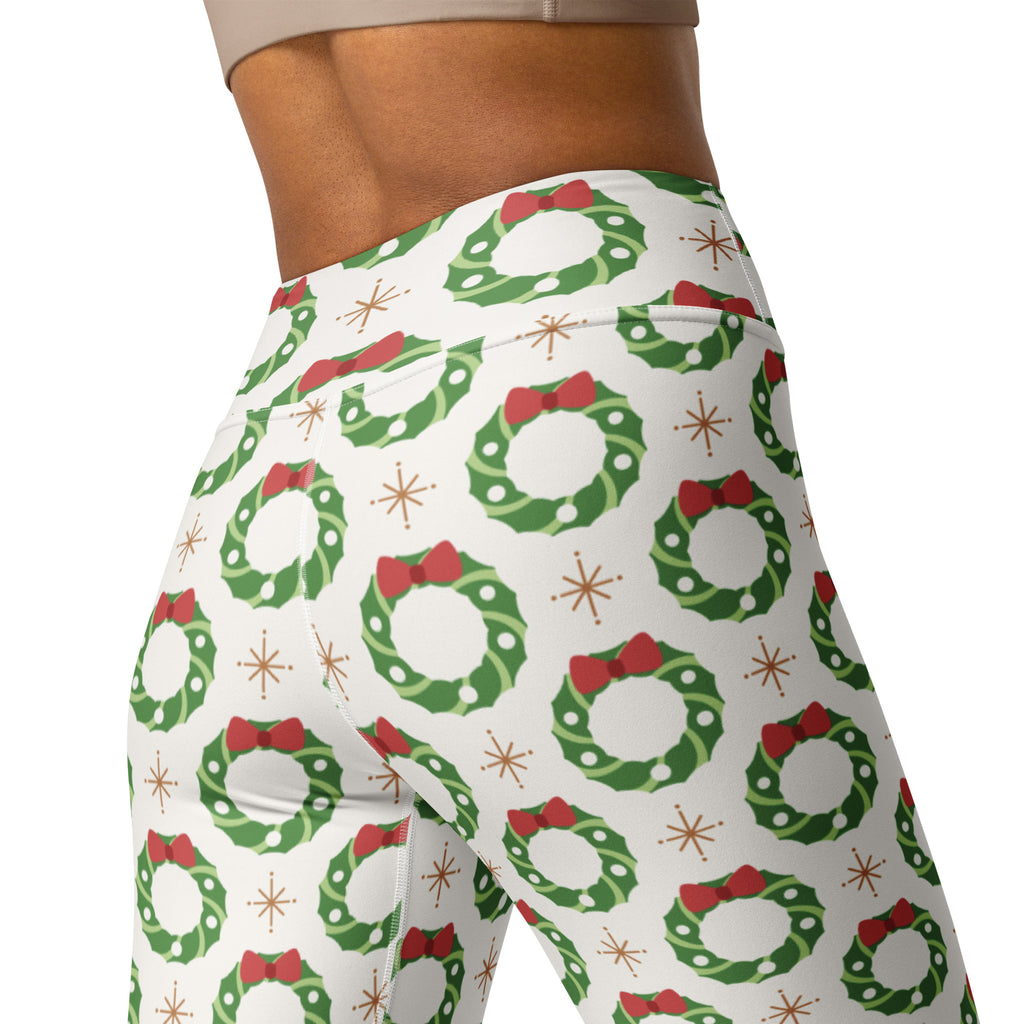 White high-waisted buttery soft yoga leggings with festive green wreaths red bows and gold starburst accents for women
