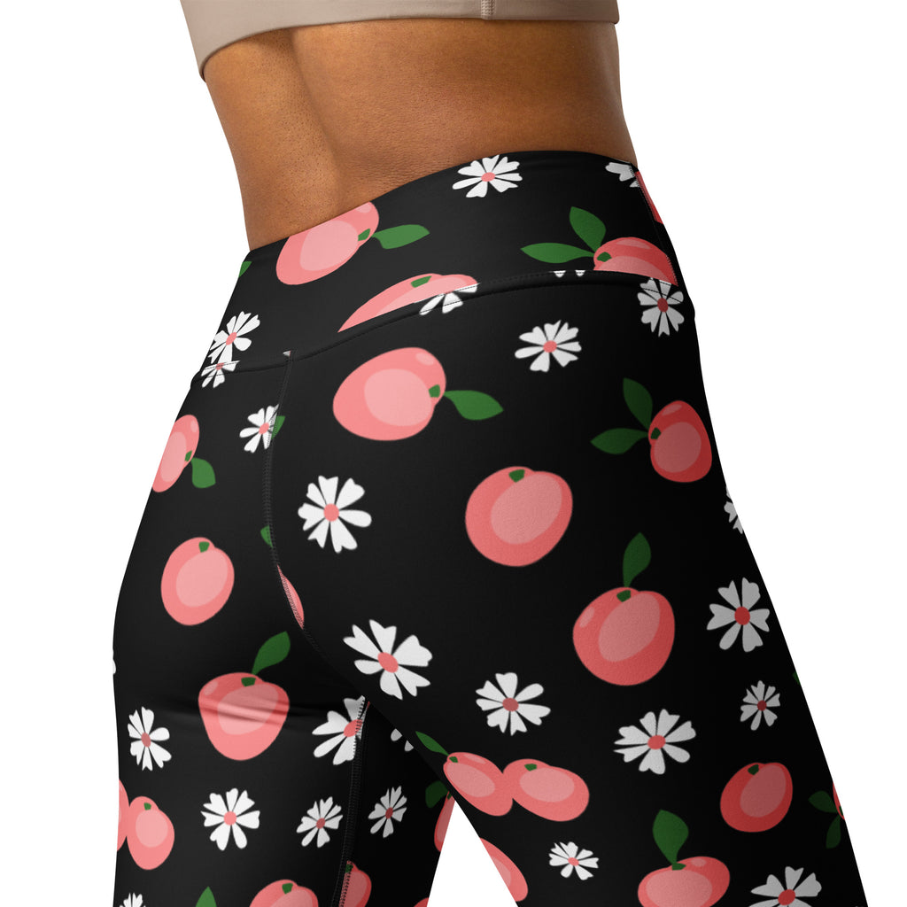 Black high-waisted buttery soft yoga leggings with a playful pattern of pink peaches and white daisies with green leaves