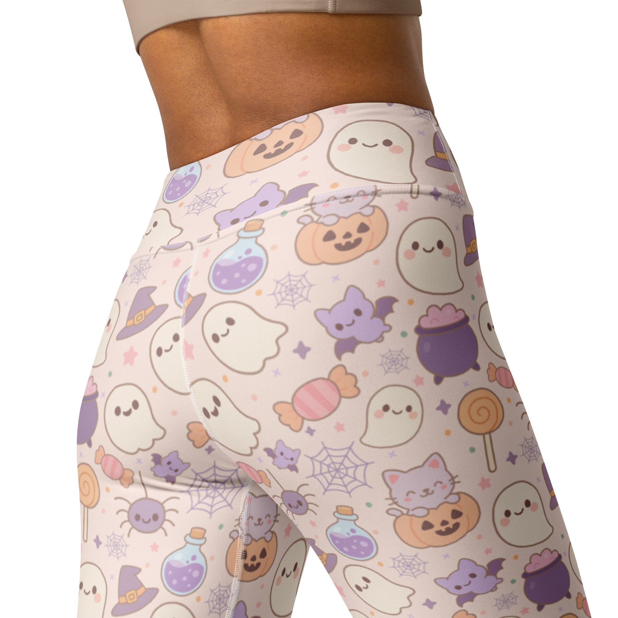 Women’s pastel pink buttery soft yoga leggings with halloween ghosts bats pumpkins and candy in purple orange hues