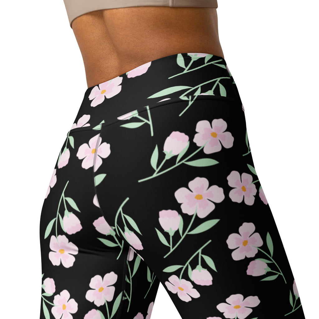 Women’s black high-waisted floral buttery soft yoga leggings with delicate pink flowers and green stems and leaves