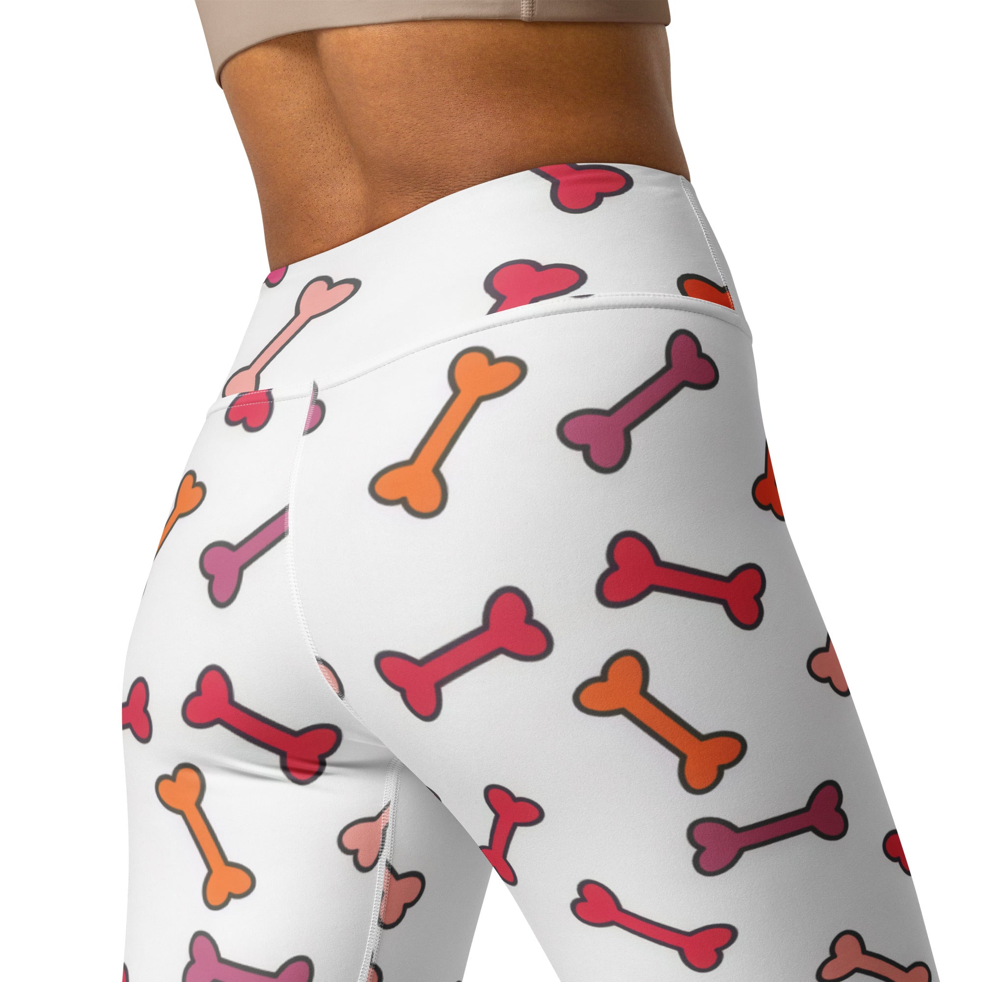 White high-waisted buttery soft yoga leggings with colorful red orange and pink cartoon dog bone pattern for women