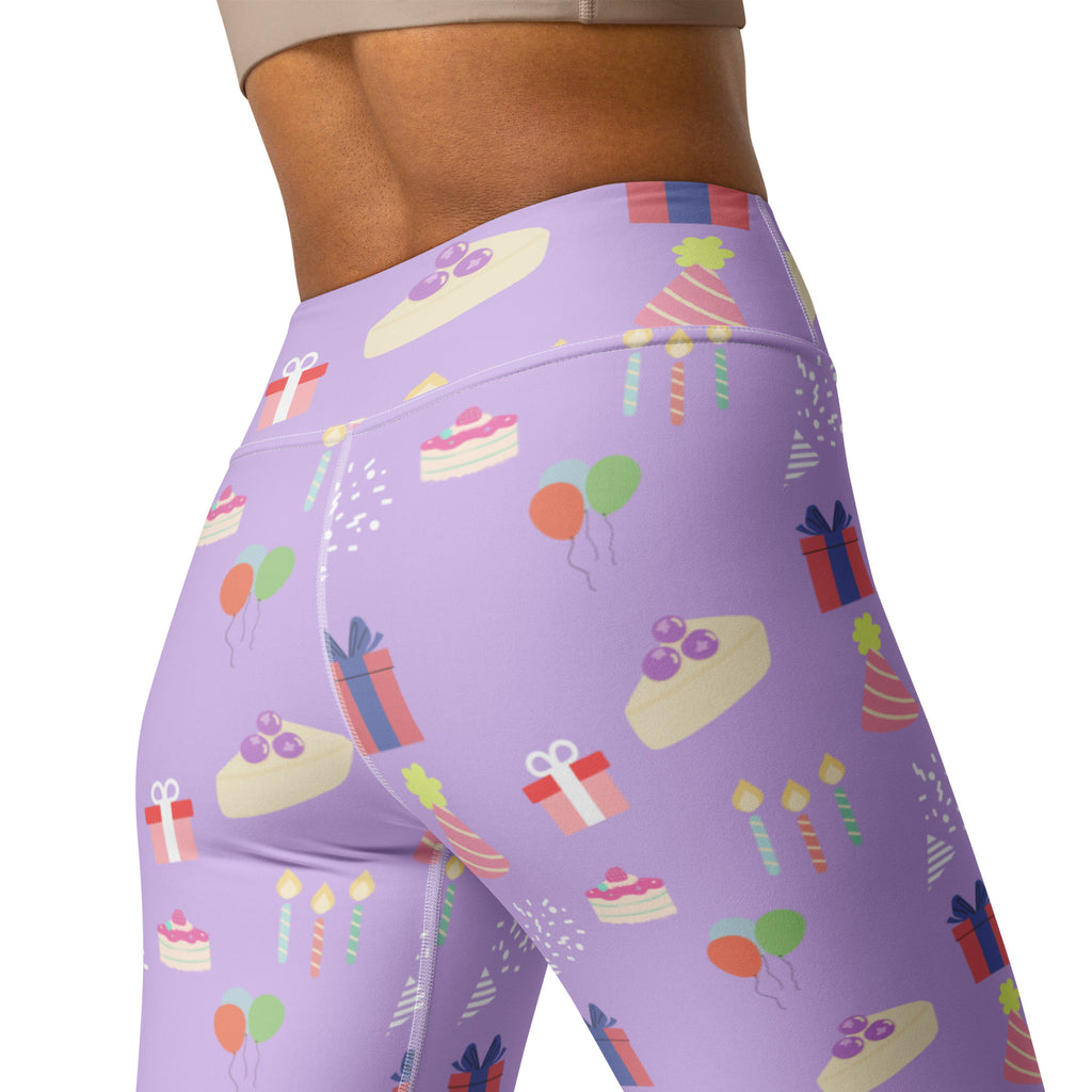 Women’s purple high waisted buttery soft yoga leggings with playful birthday pattern of cakes gifts balloons and candles