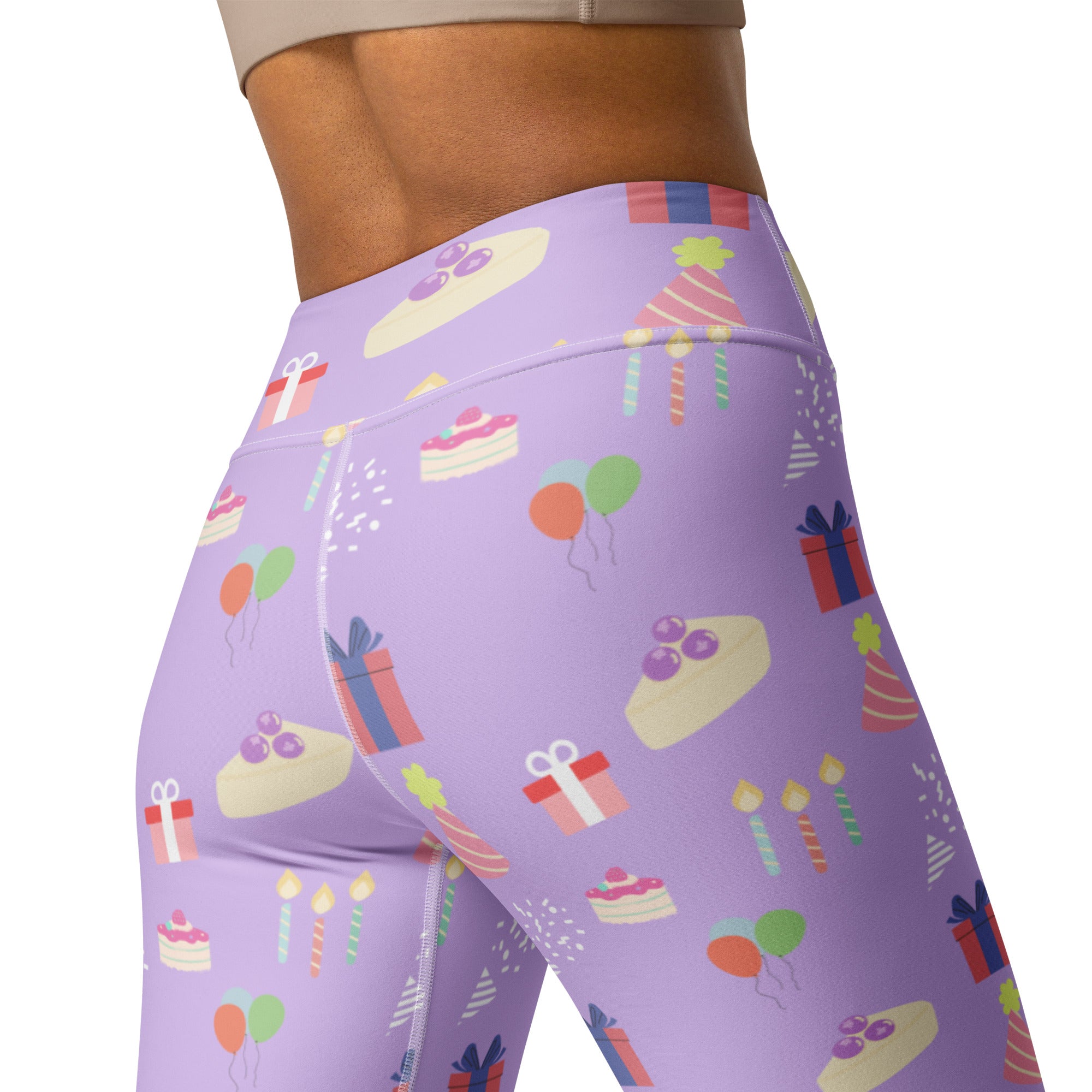 Women’s purple high waisted buttery soft yoga leggings with playful birthday pattern of cakes gifts balloons and candles