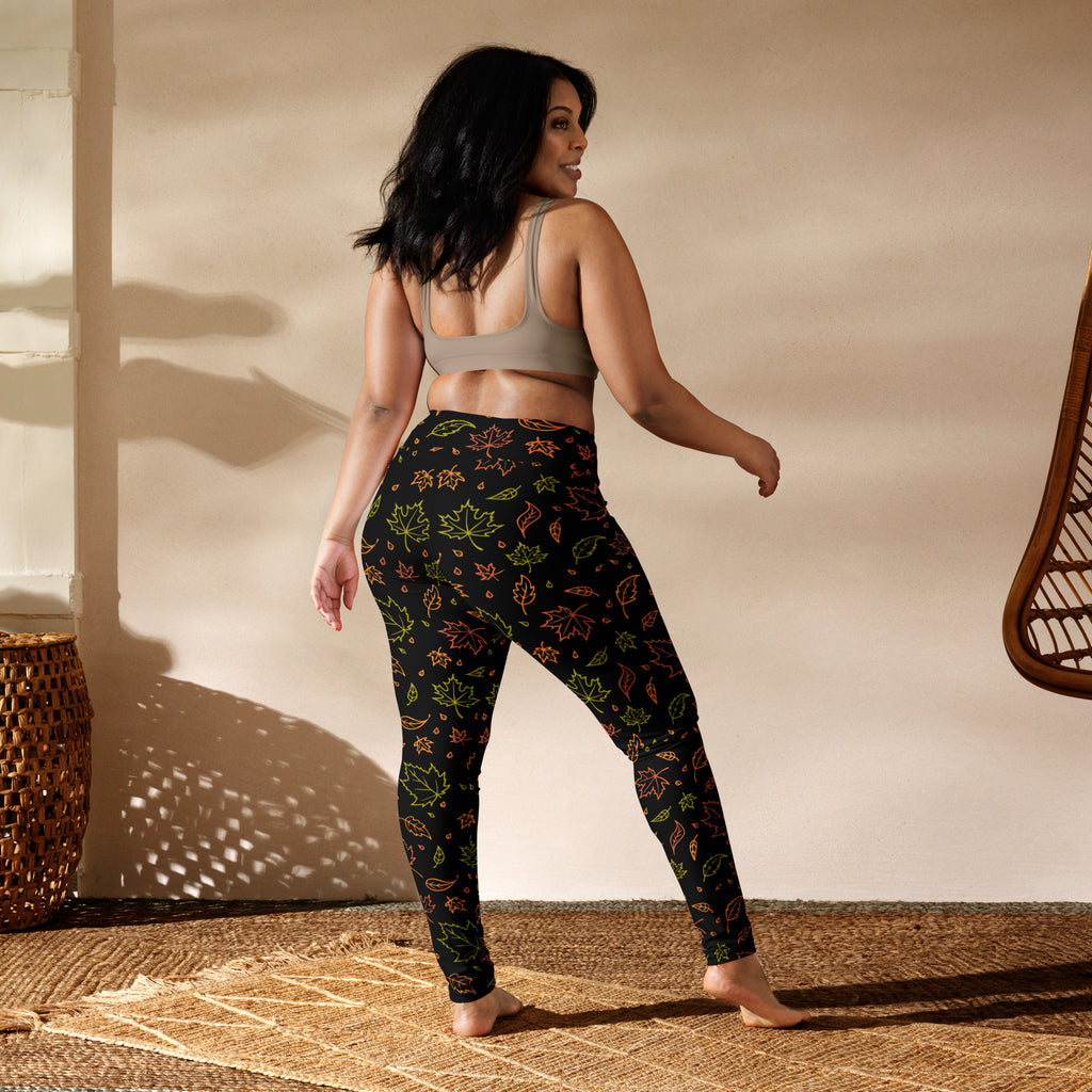 Black women’s buttery soft yoga leggings with vibrant green orange and yellow fall leaves pattern