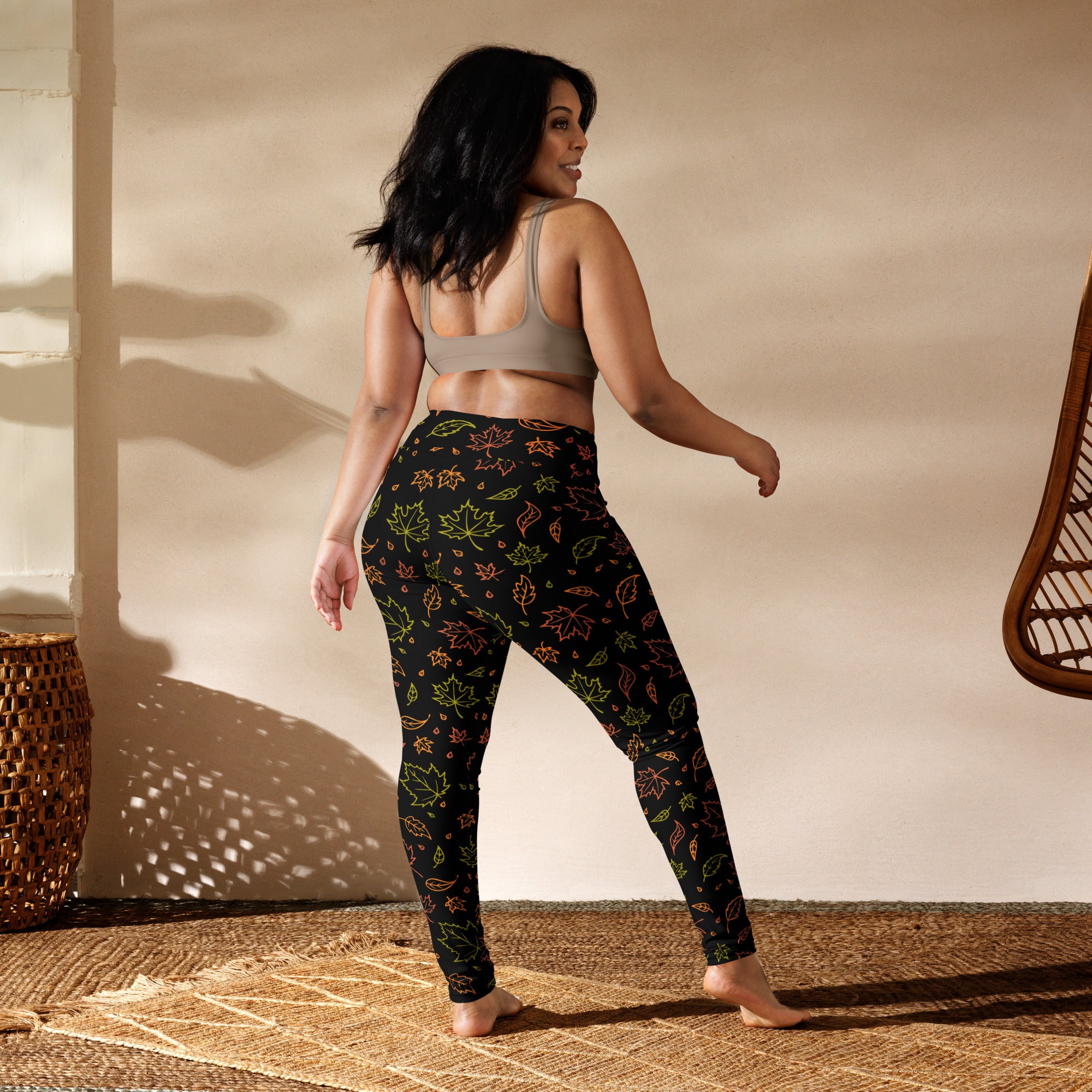 Black women’s buttery soft yoga leggings with vibrant green orange and yellow fall leaves pattern