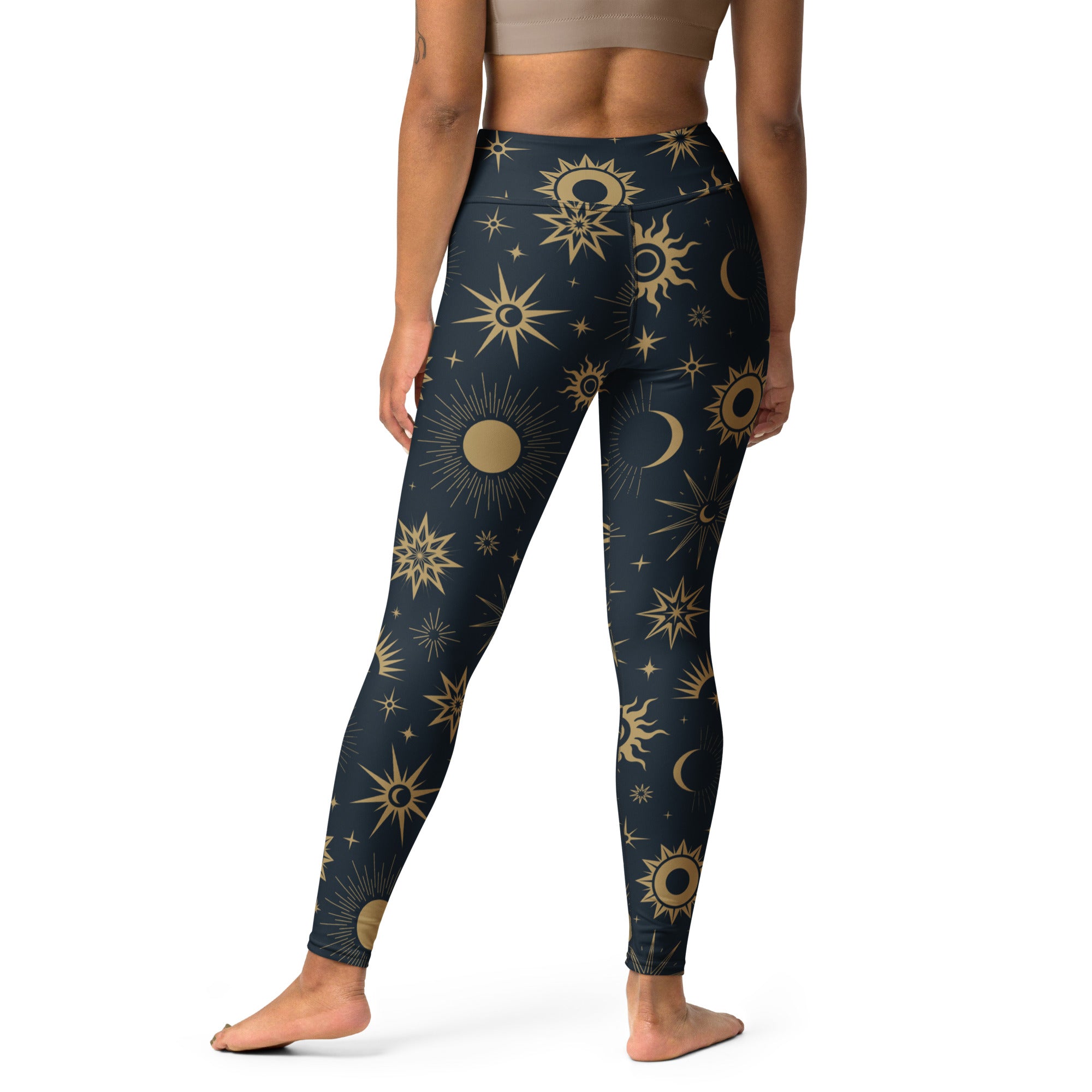 Dark blue high-waisted buttery soft yoga leggings with a vibrant gold celestial sun moon and star pattern