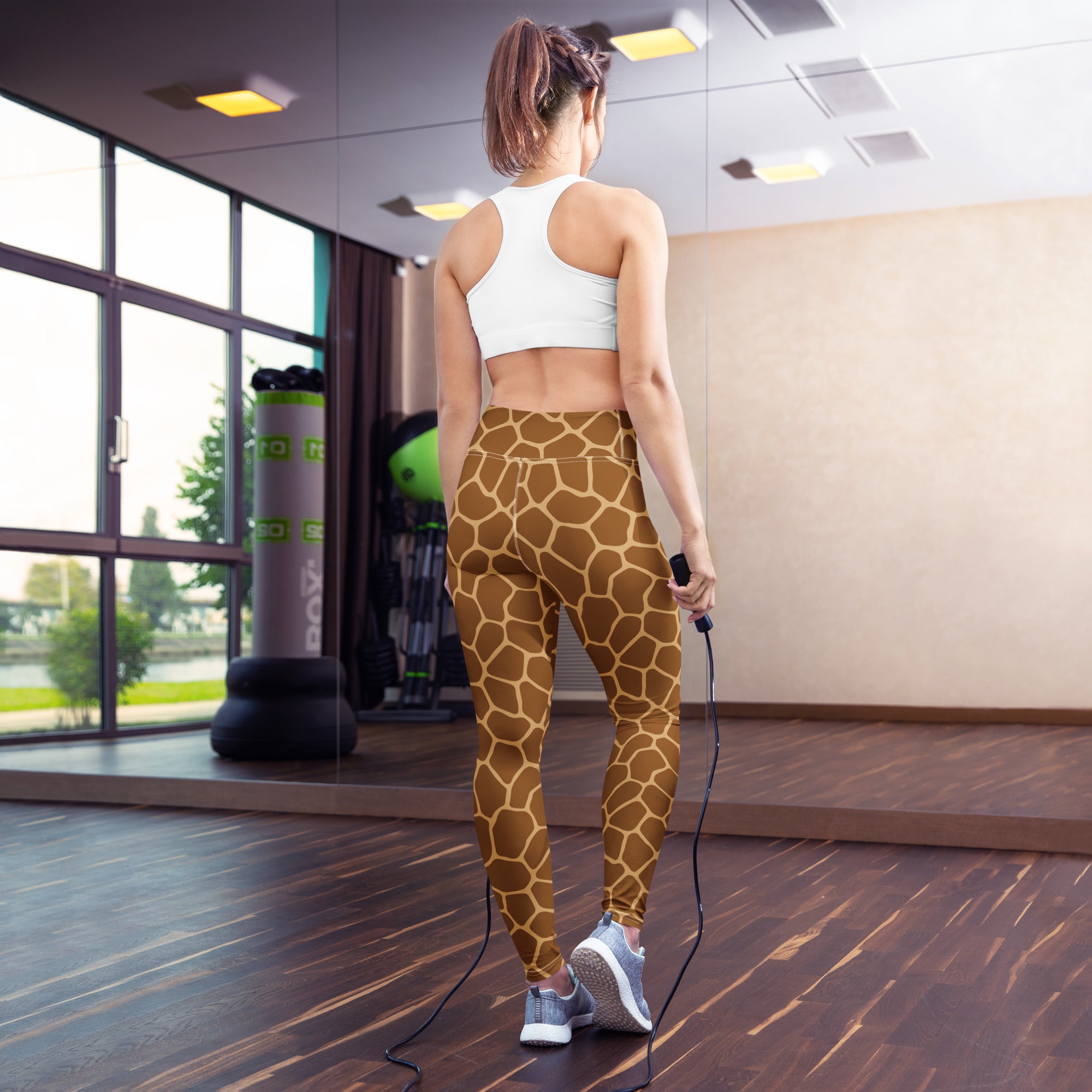 Women’s giraffe print buttery soft yoga leggings in brown and tan high-waisted design shown from the back side