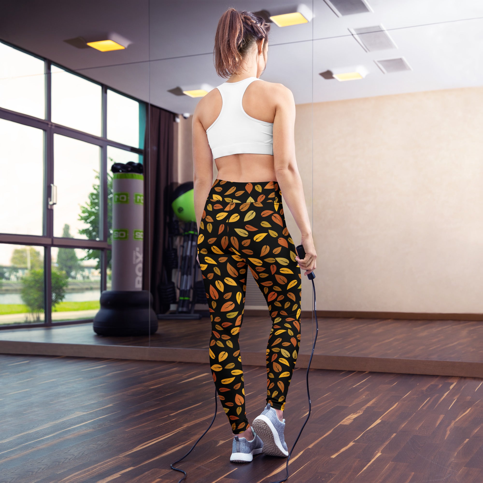 Women’s buttery soft black leggings with vibrant orange and yellow gold leaves perfect for yoga and autumn wear