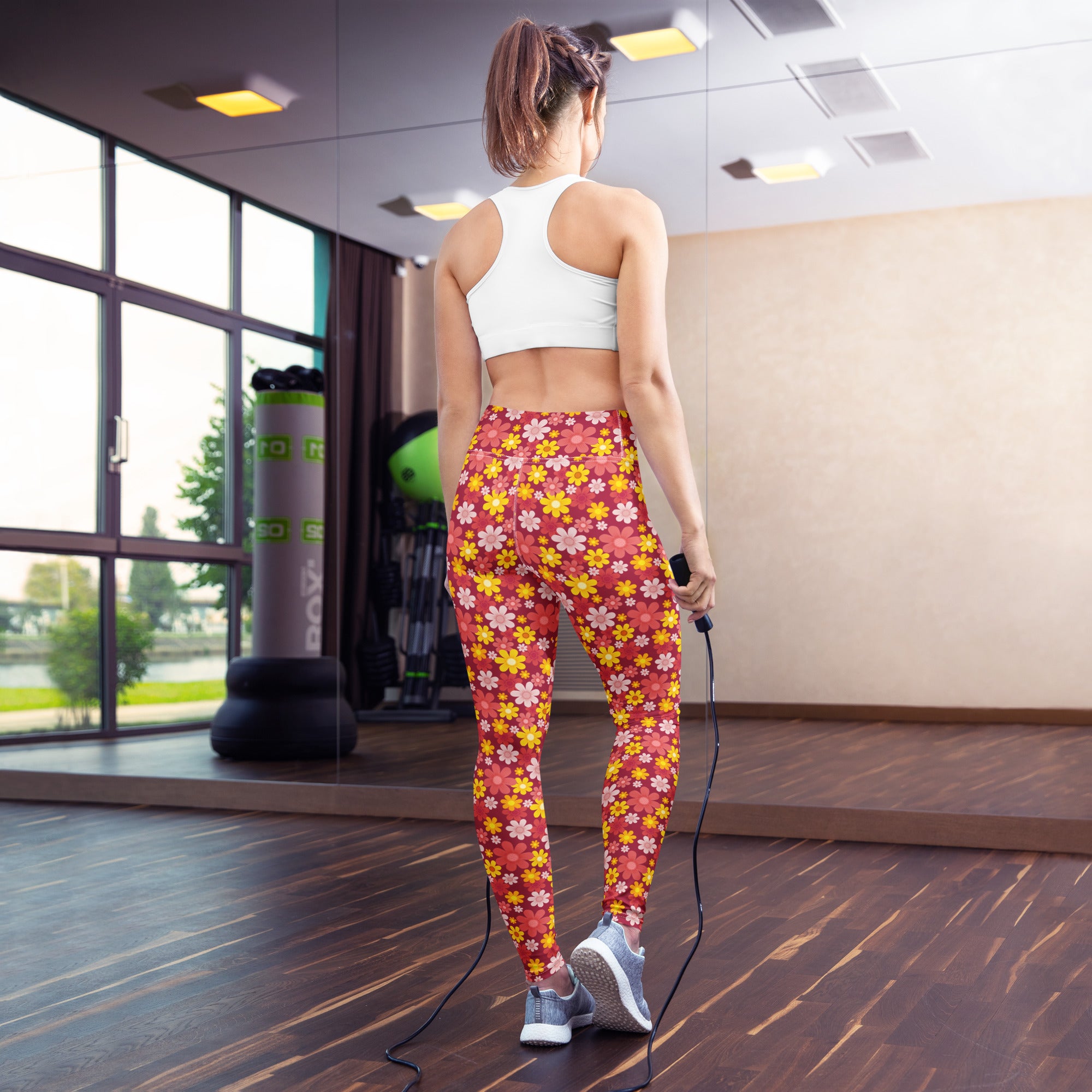 A woman wearing women’s red floral buttery soft high-waisted yoga leggings exercising in a gym