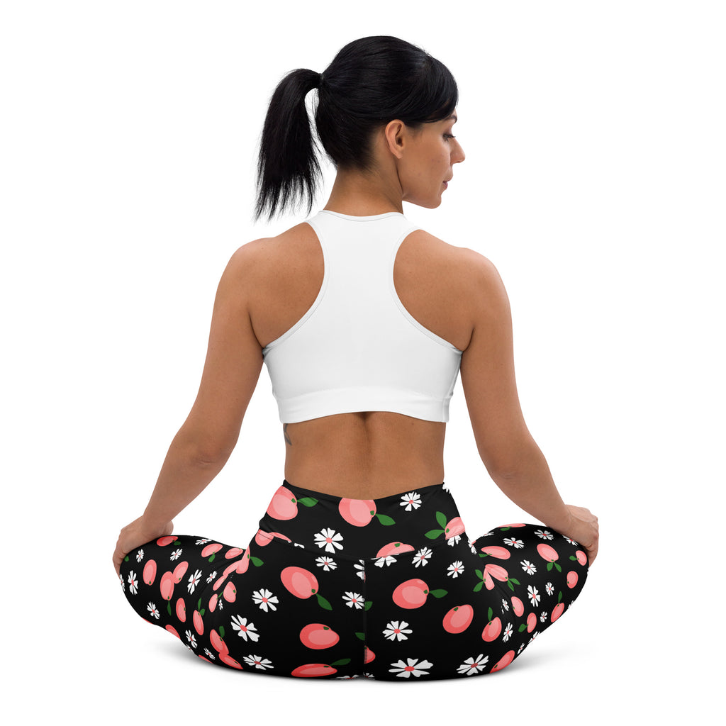 Women’s black buttery soft yoga leggings with a playful pattern of pink peaches and white daisies
