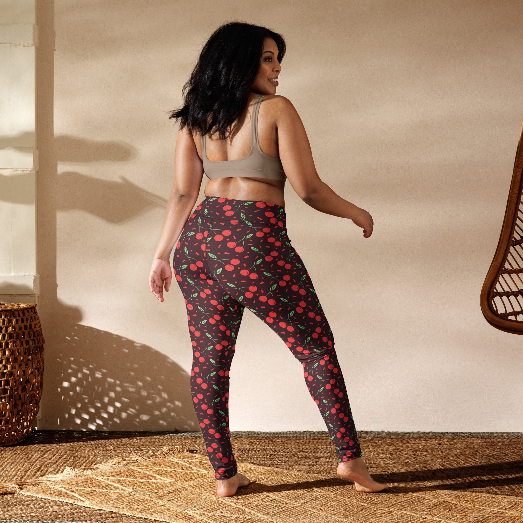 Women’s red cherry buttery soft yoga leggings with high-waisted fit, green leaves, and dark background pattern