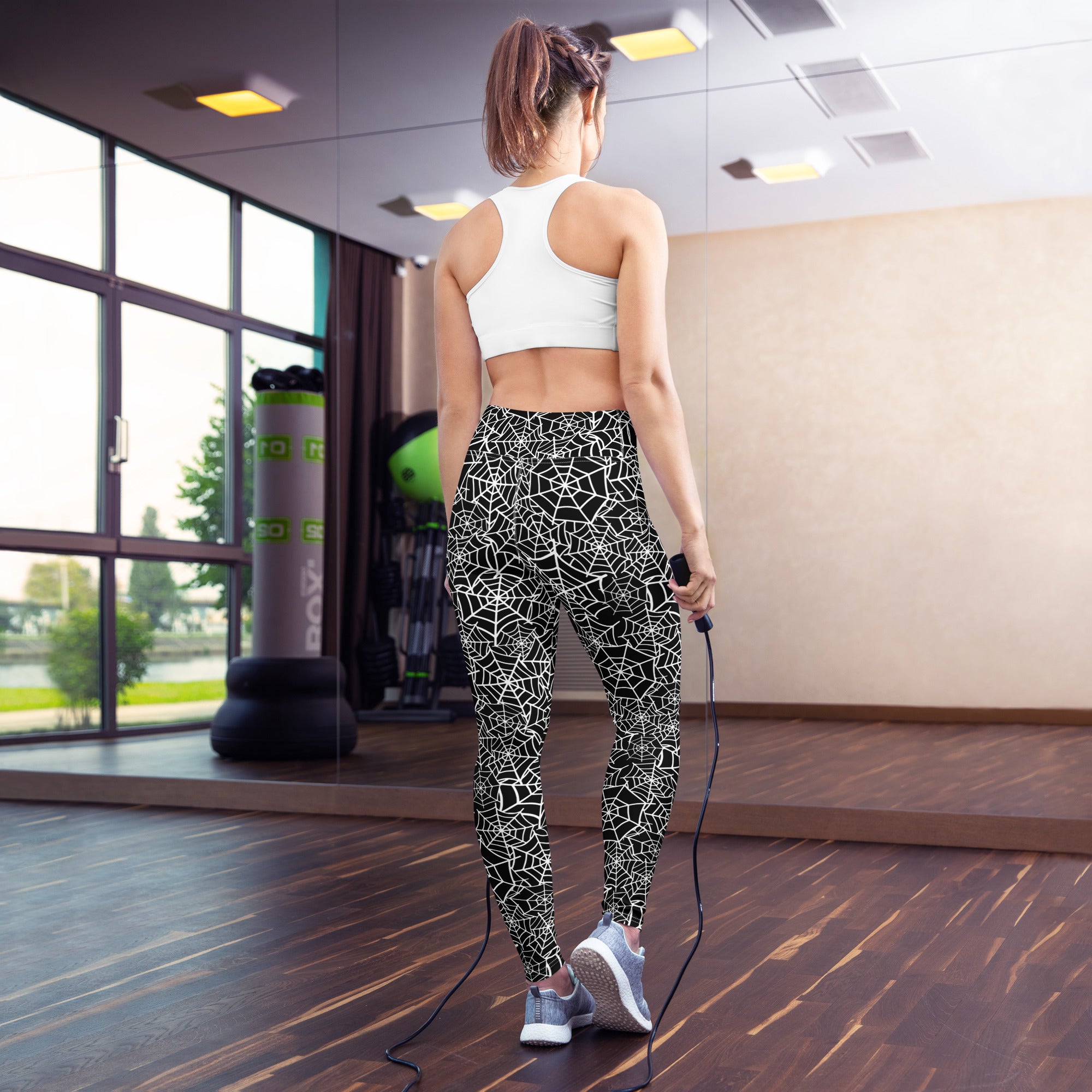 Women’s black and white spiderweb high-waisted buttery soft yoga leggings shown from the back side
