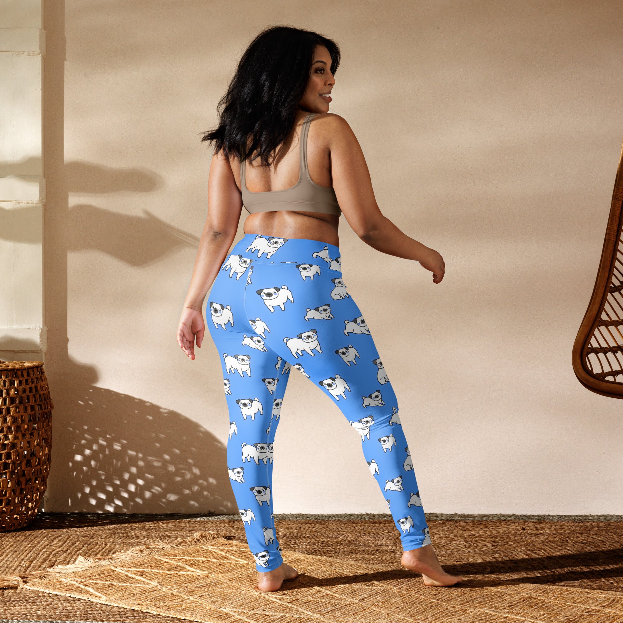 Women’s blue buttery soft yoga leggings with a repeating pattern of white pug dogs for comfortable wear