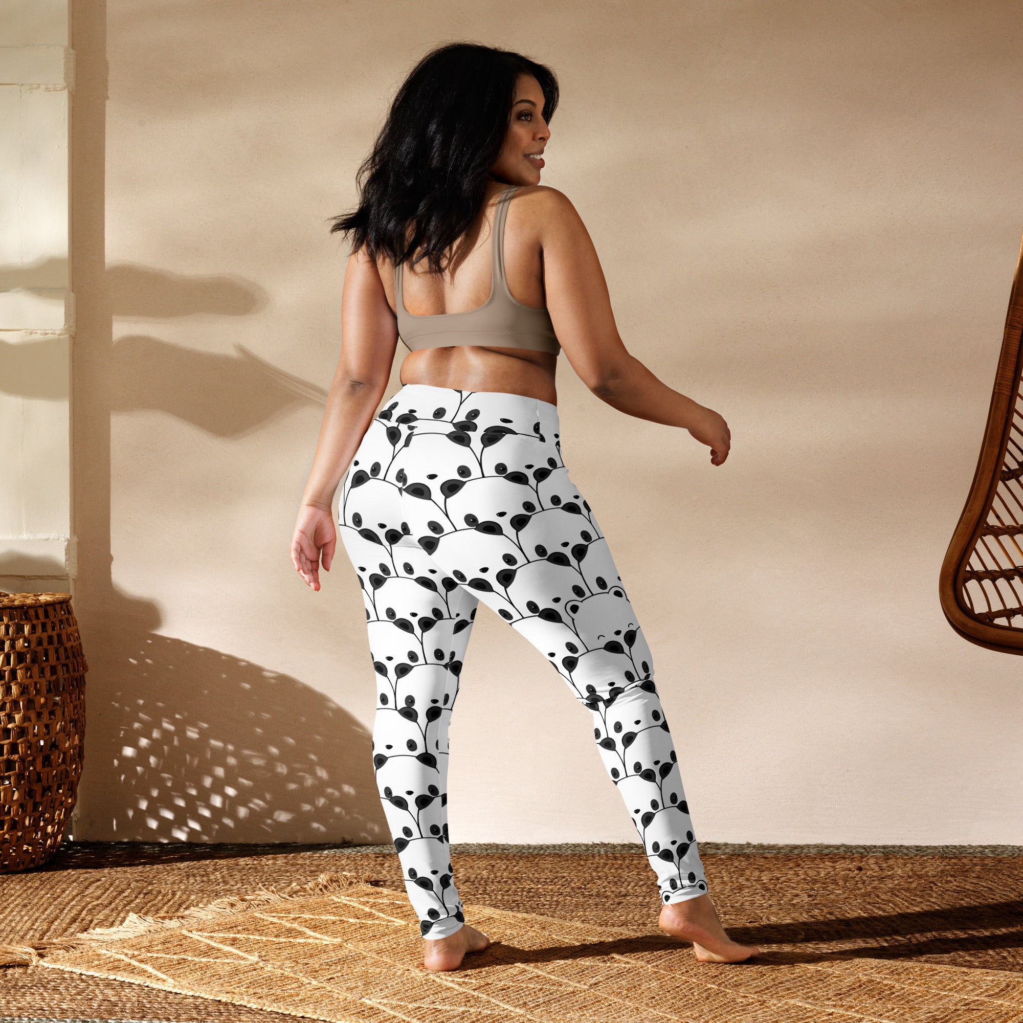 White womens buttery soft yoga leggings with playful black panda face pattern and leafy vine design