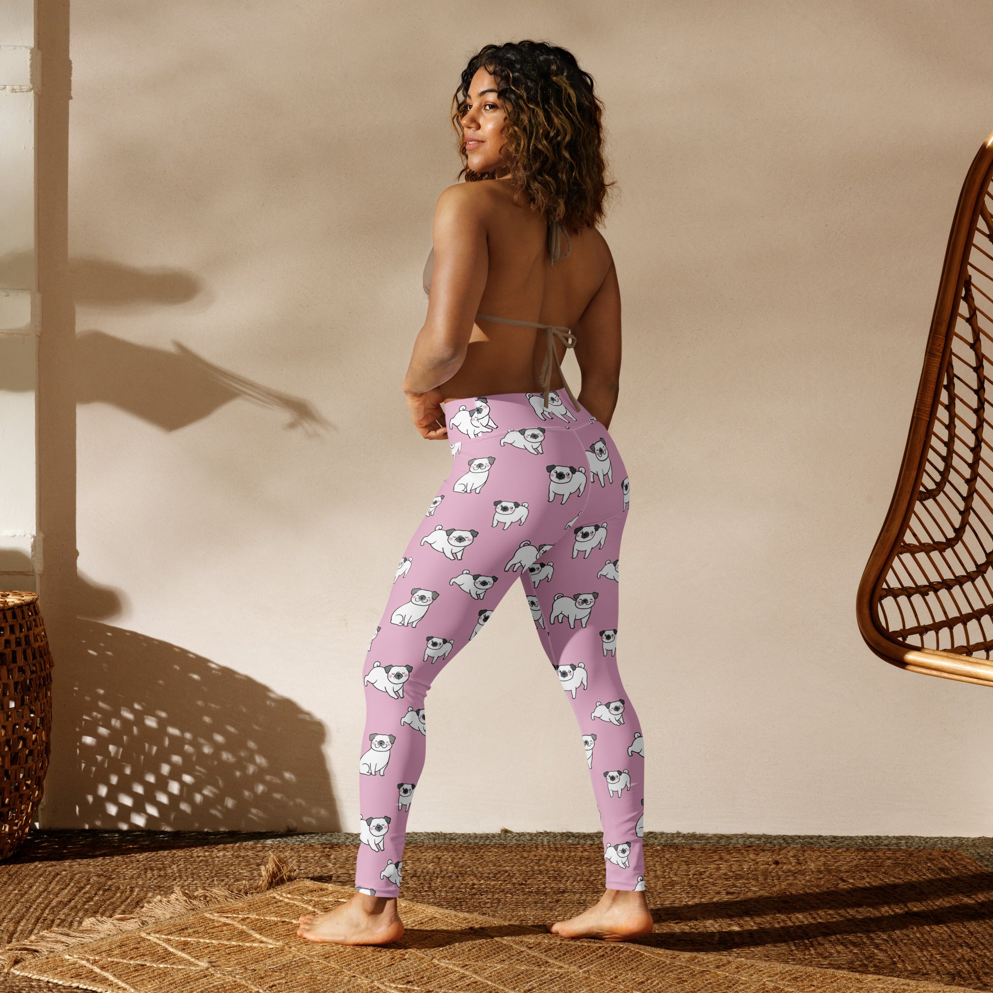 Women’s pink buttery soft yoga leggings with a repeating pattern of white pug illustrations