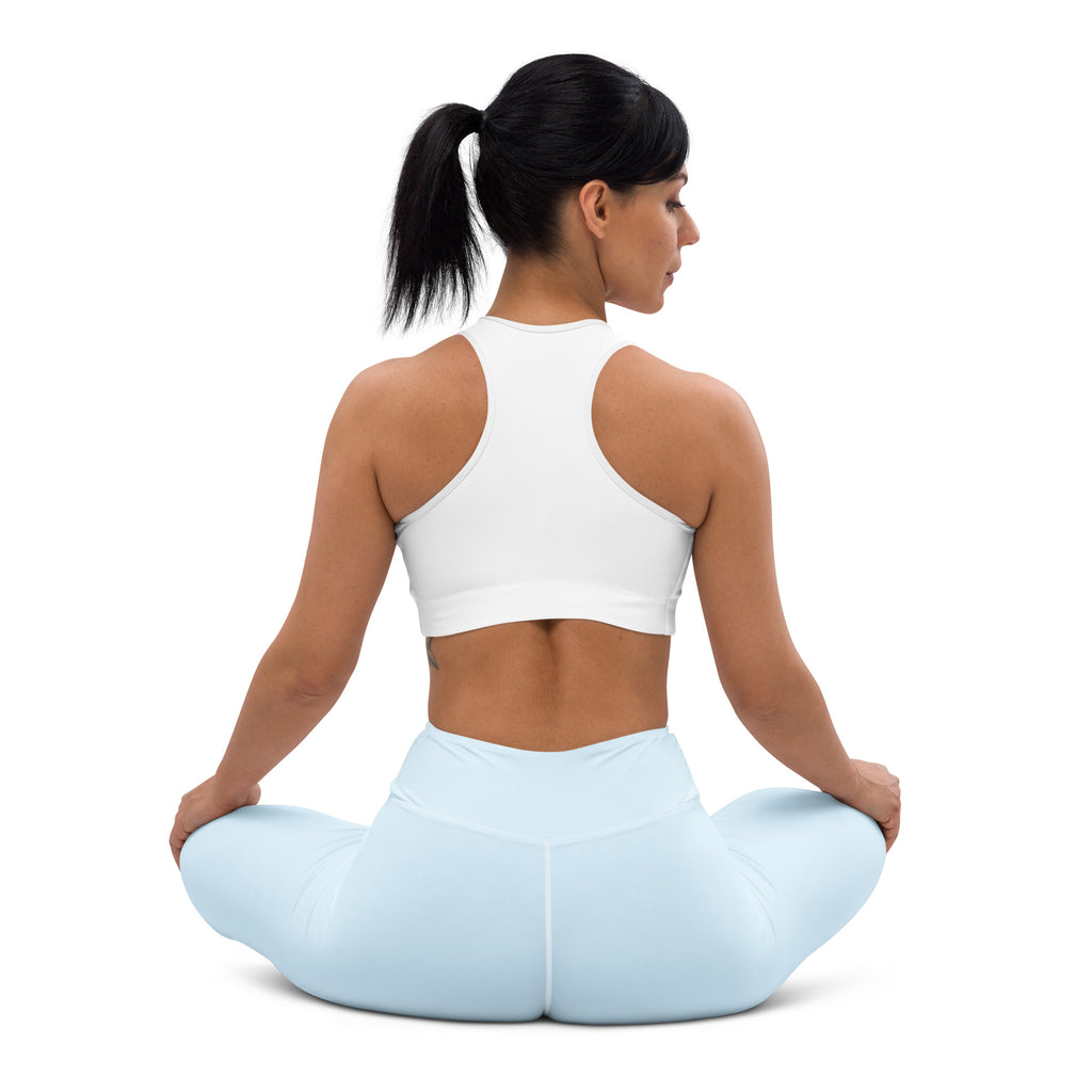 A woman wearing white sports bra and nimbus blue buttery soft high-waisted yoga leggings in a seated pose