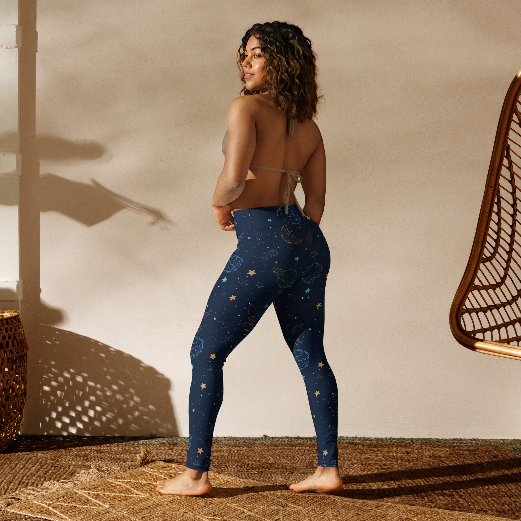 Dark blue buttery soft women’s yoga leggings with a colorful celestial pattern of stars moons and planets
