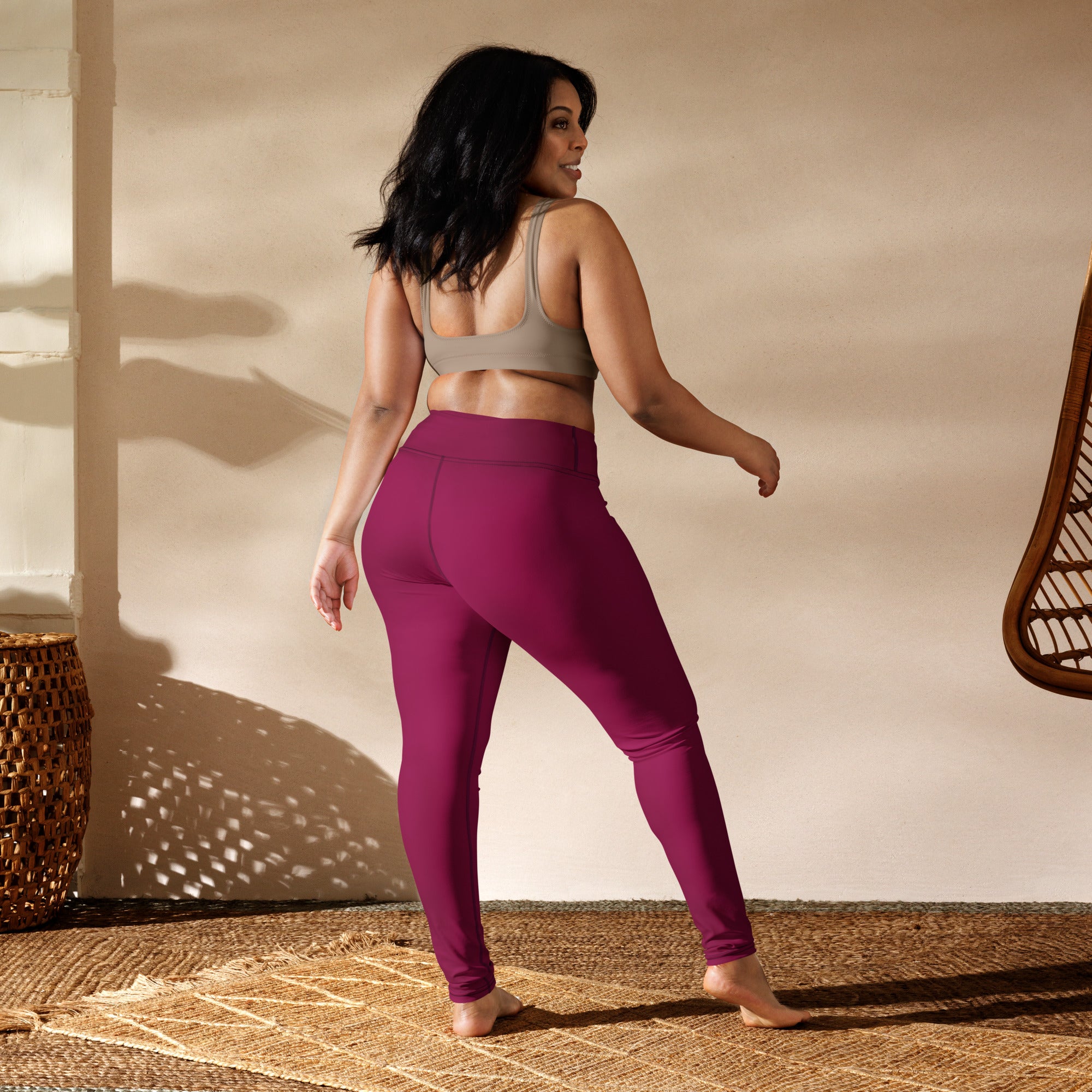 A pair of women’s dark magenta high-waisted buttery soft yoga leggings made from stretchy athletic fabric