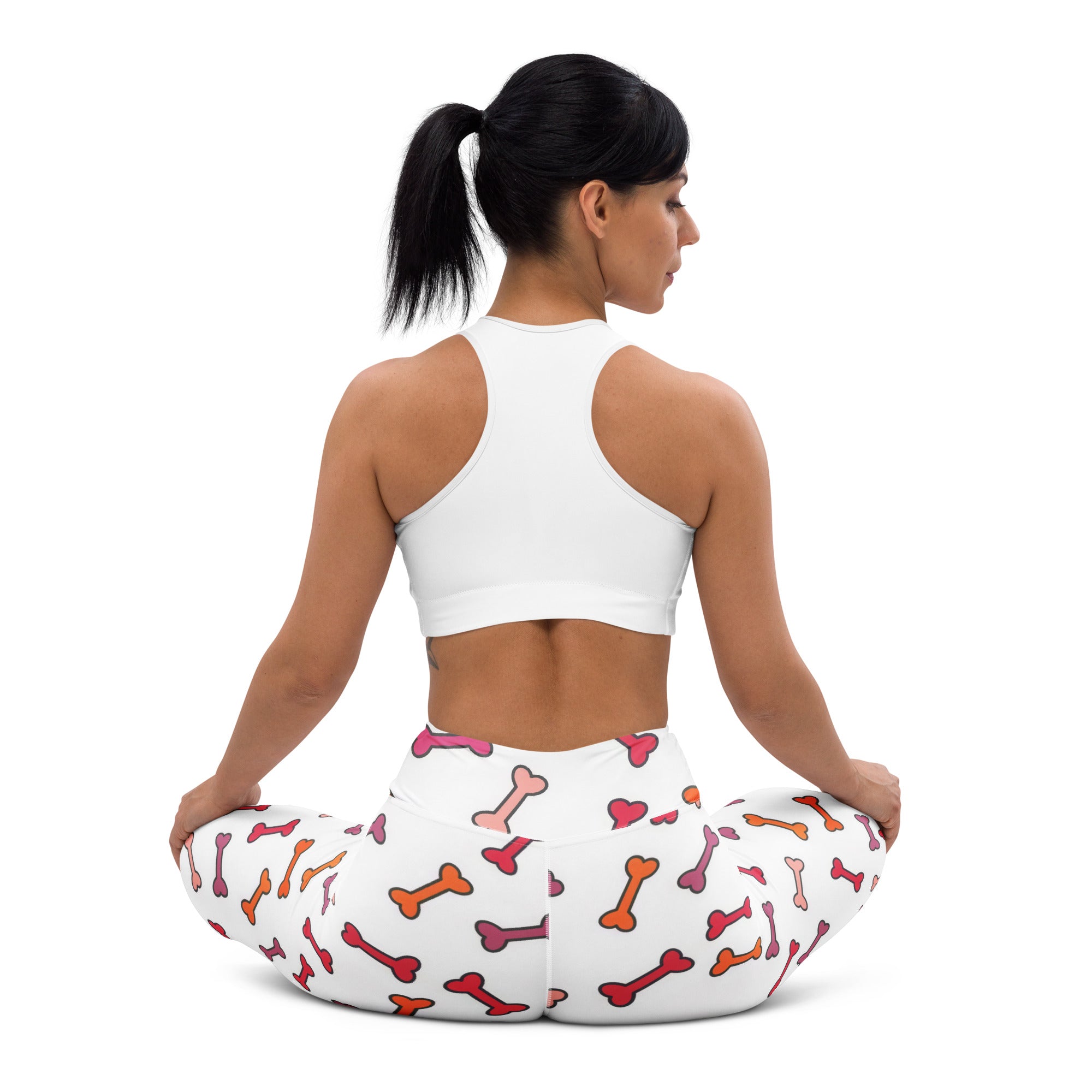 White buttery soft women’s yoga pants with colorful pink orange and red bones and hearts pattern