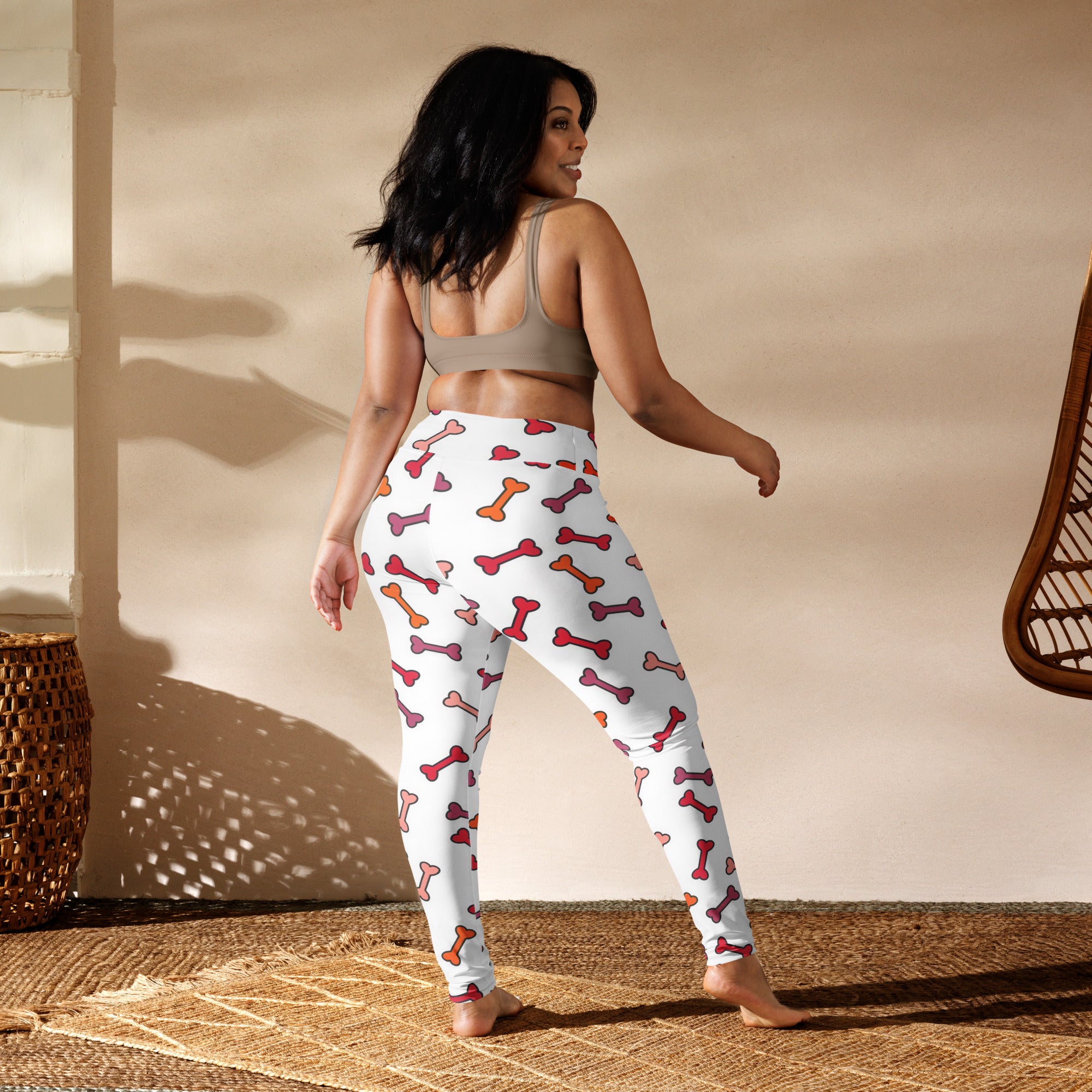 White women’s buttery soft yoga leggings with colorful pink and orange dog bone pattern for playful activewear