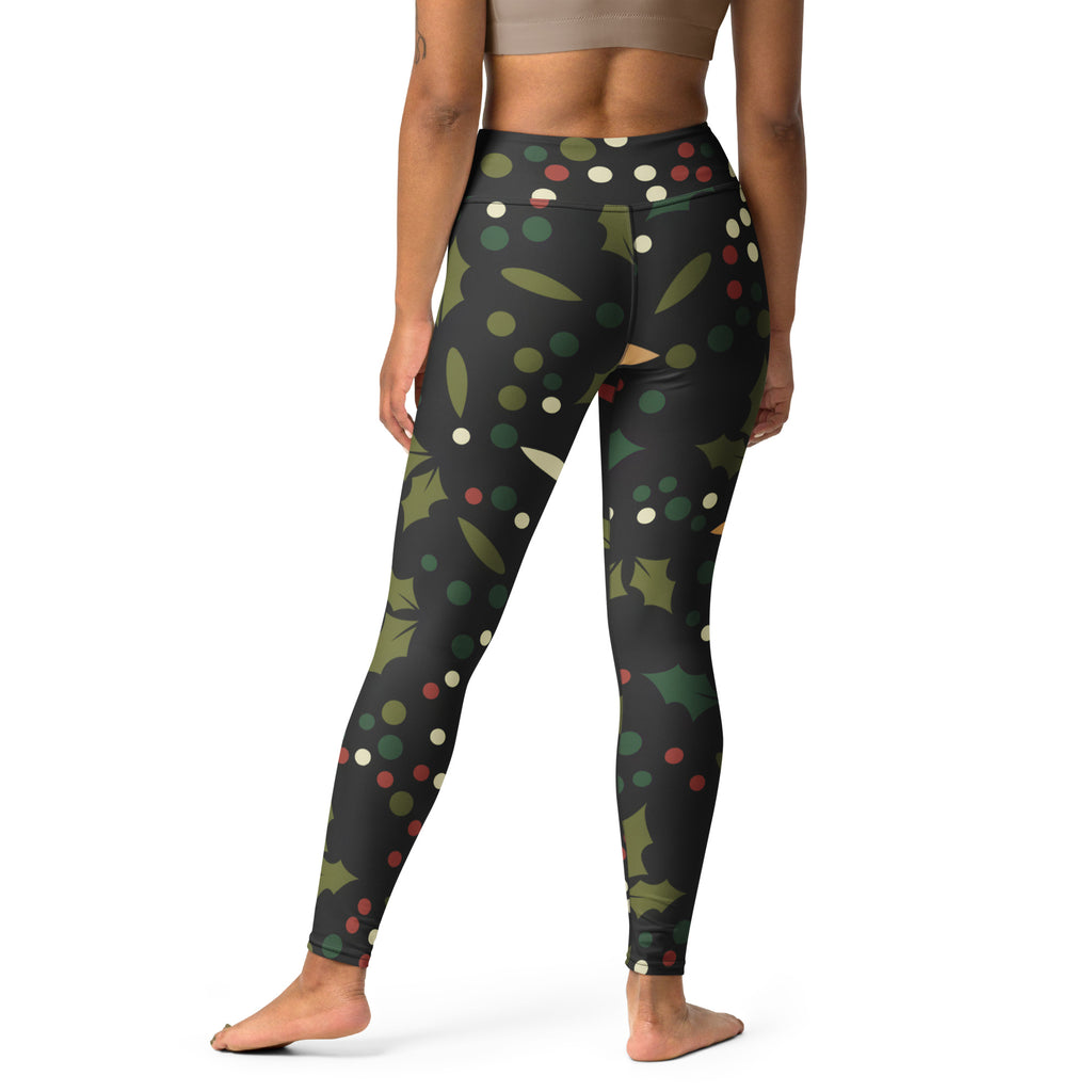 Black high-waisted buttery soft yoga leggings with festive green holly leaves and red and white berries pattern