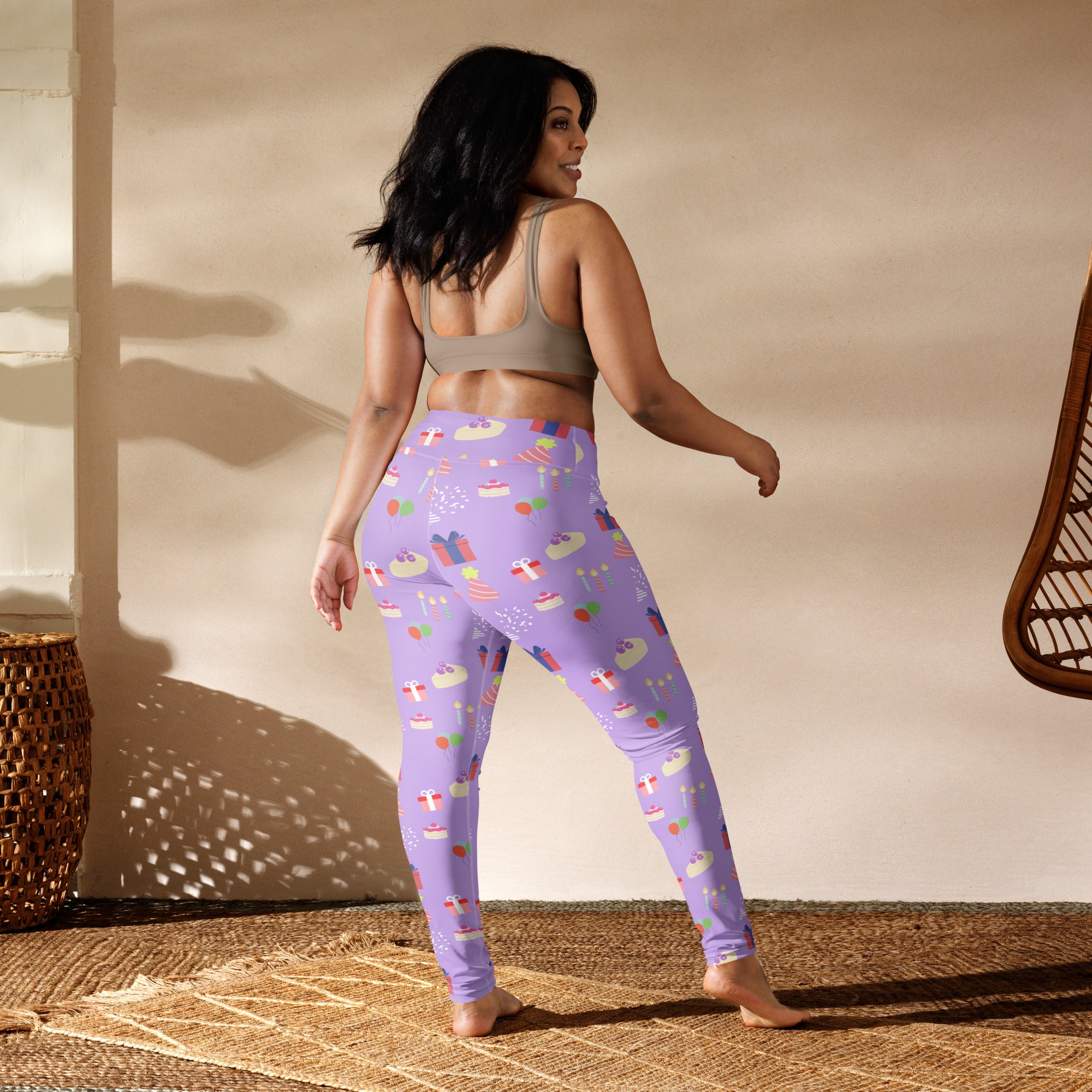 Women’s purple buttery soft yoga leggings with a playful birthday pattern of cupcakes gifts and candies